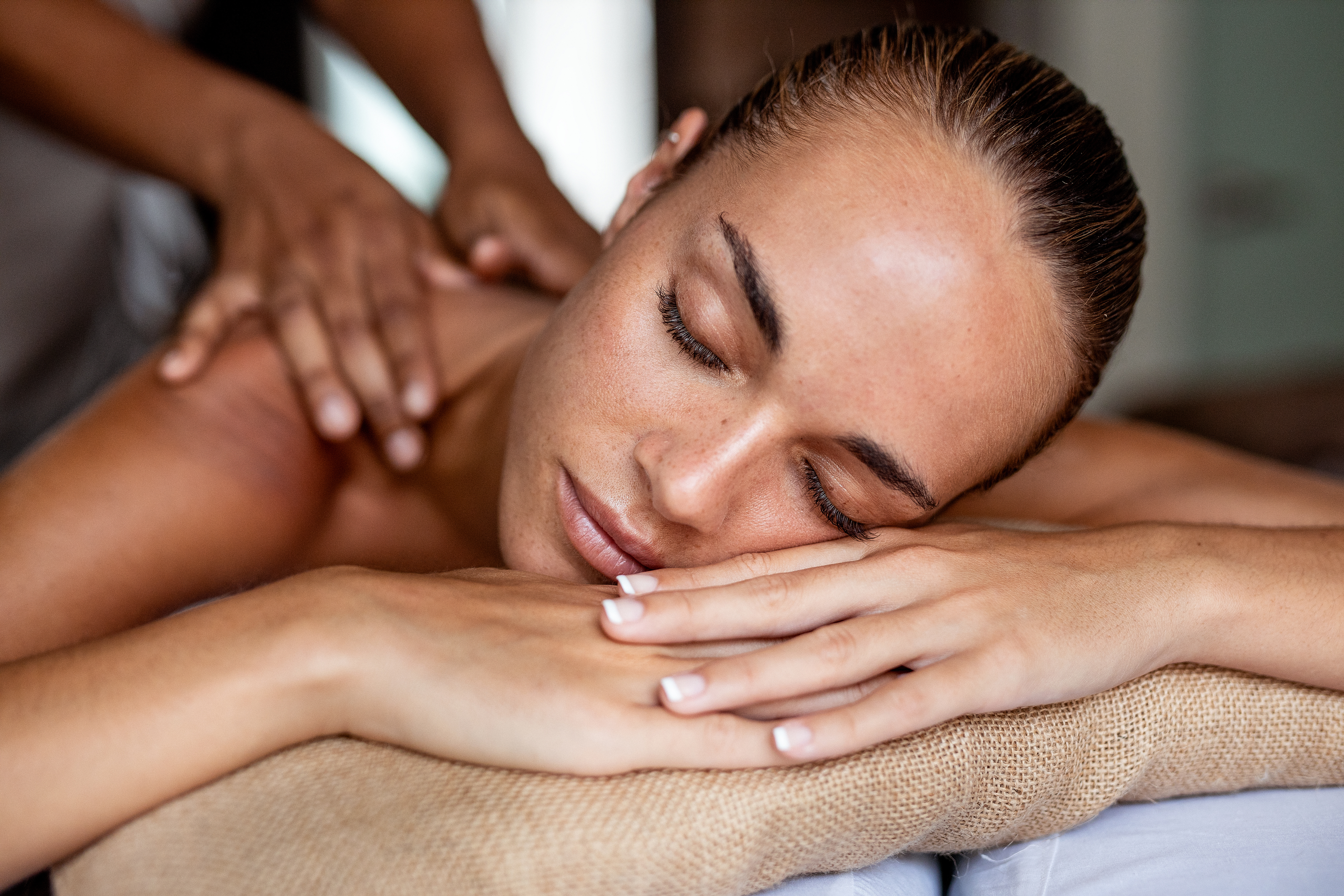 Serene woman receiving a professional back massage at a spa.