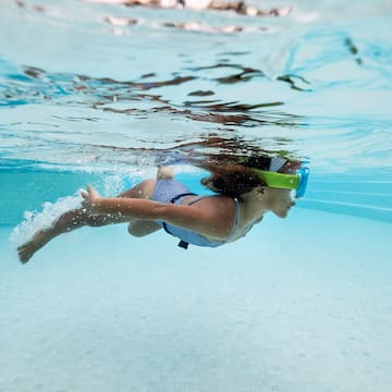 a woman swimming underwater with goggles