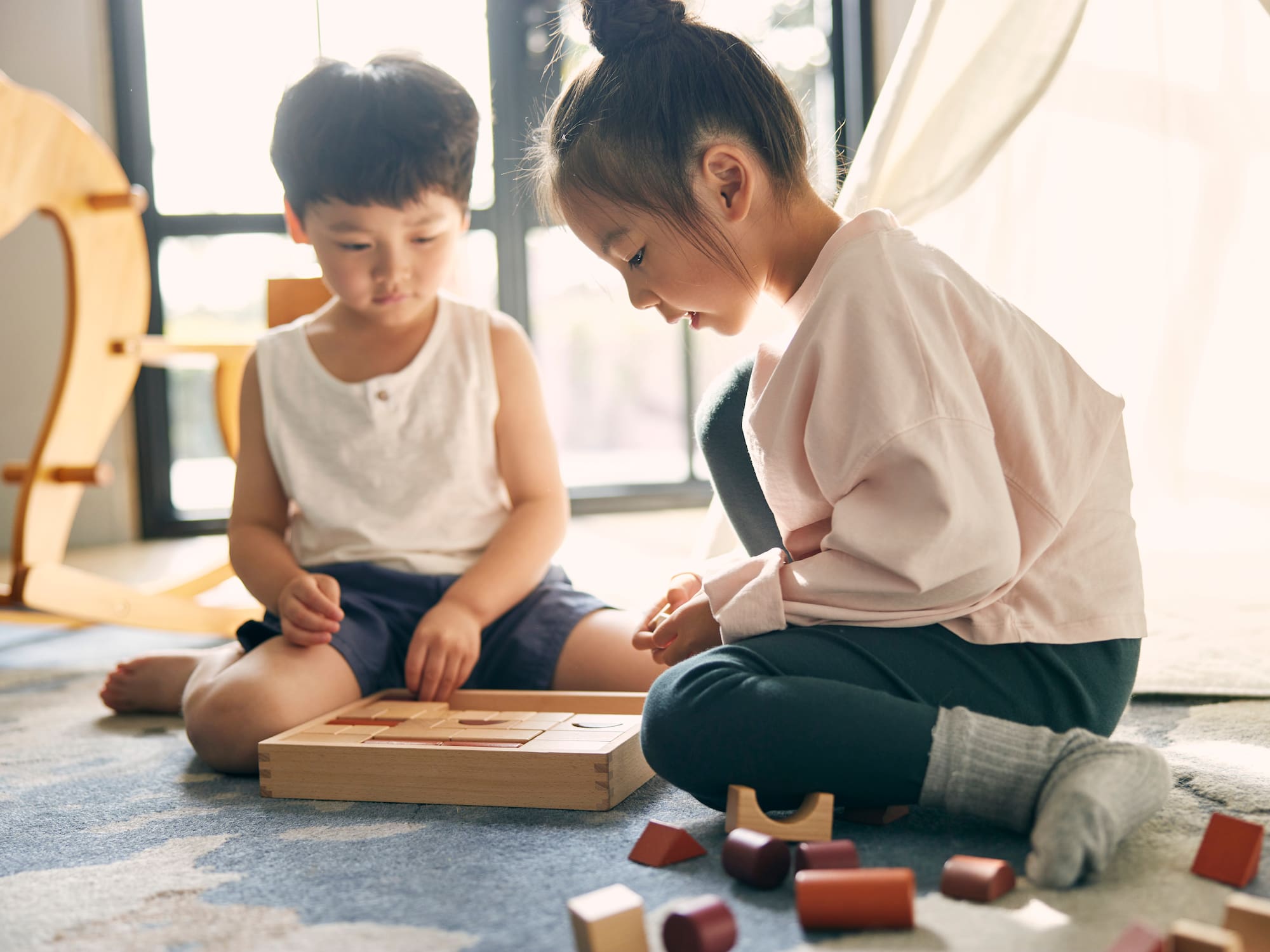 a boy and girl playing with blocks