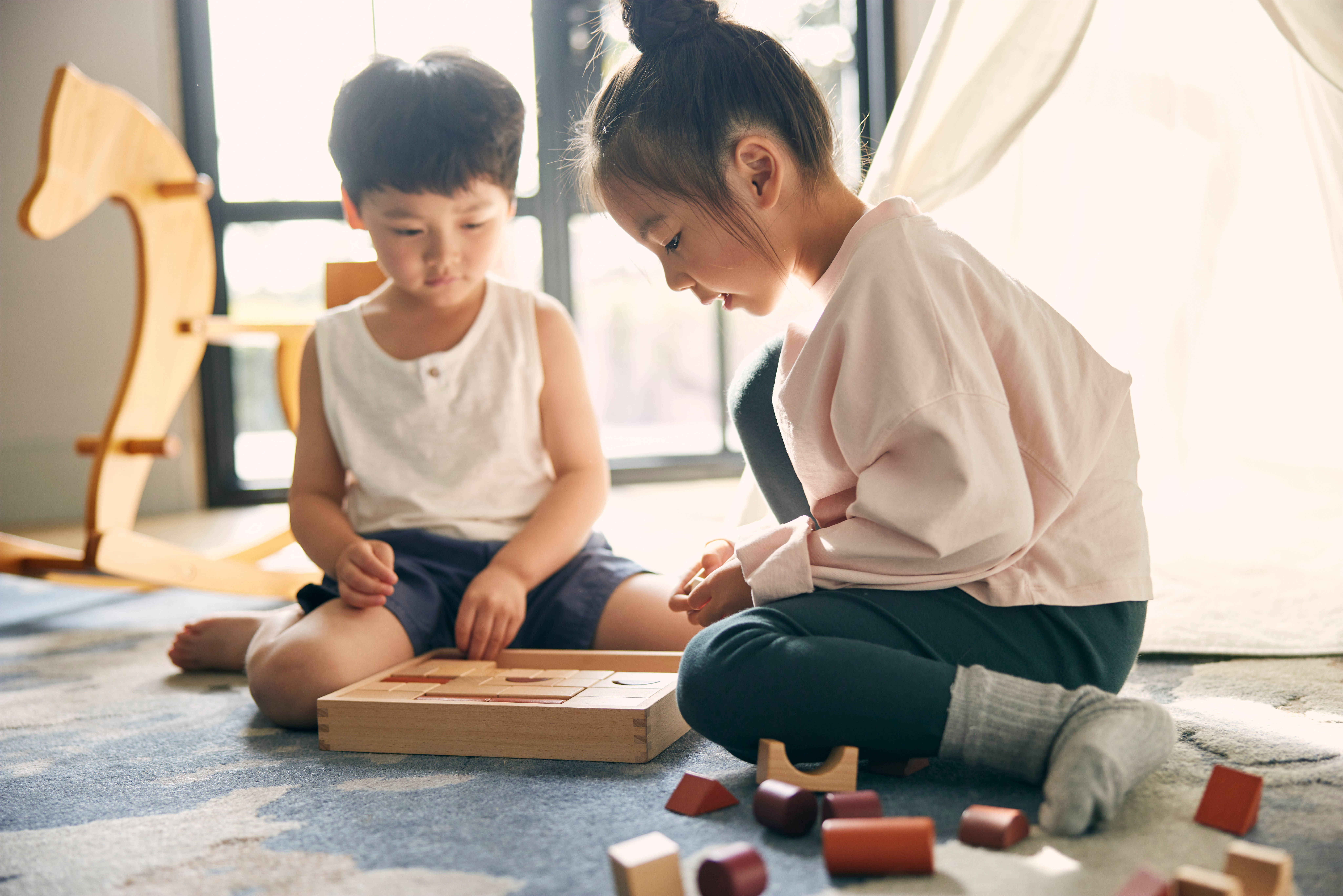 a boy and girl playing with blocks