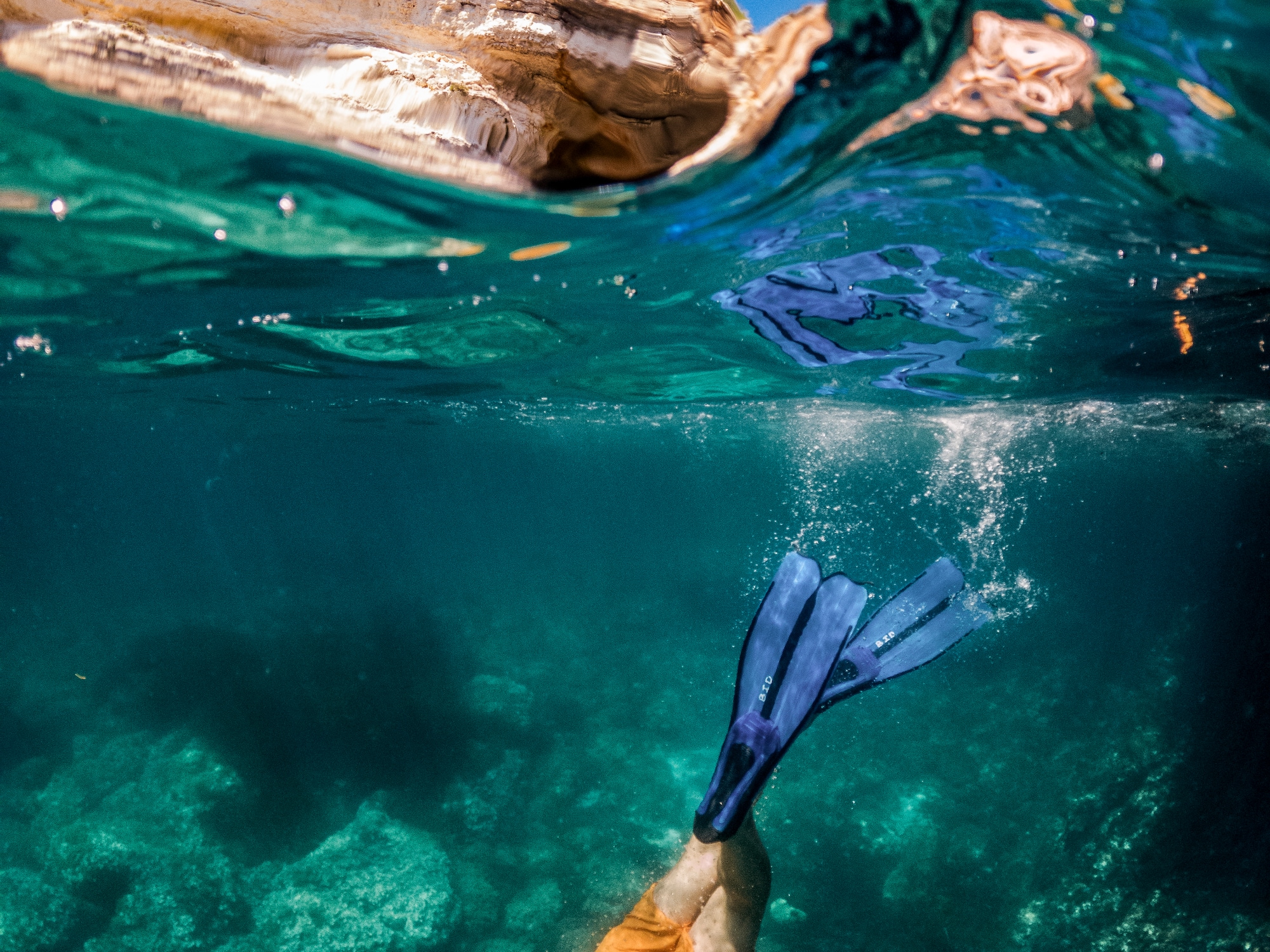 a person swimming under water with fins