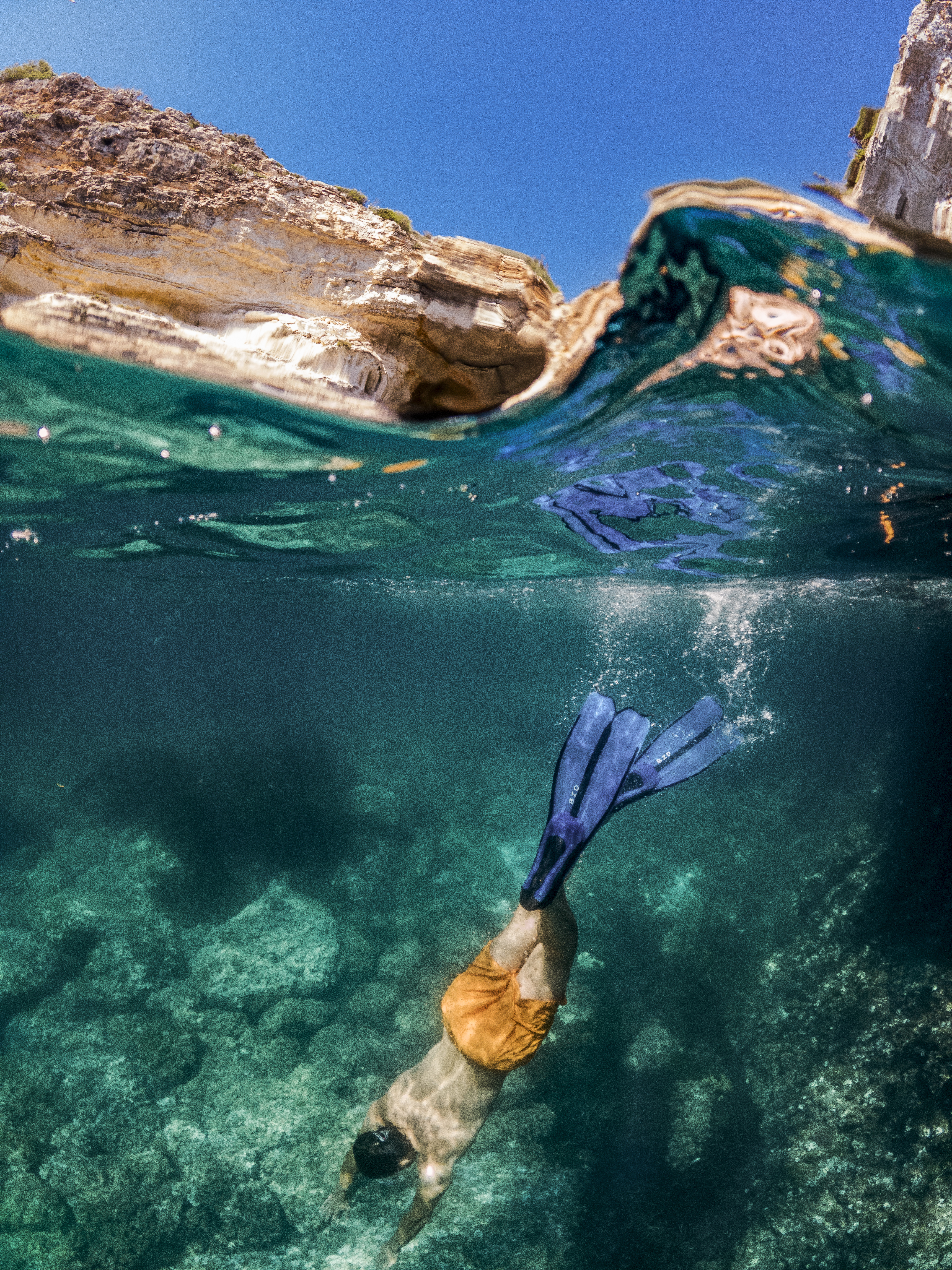 a person swimming under water with fins