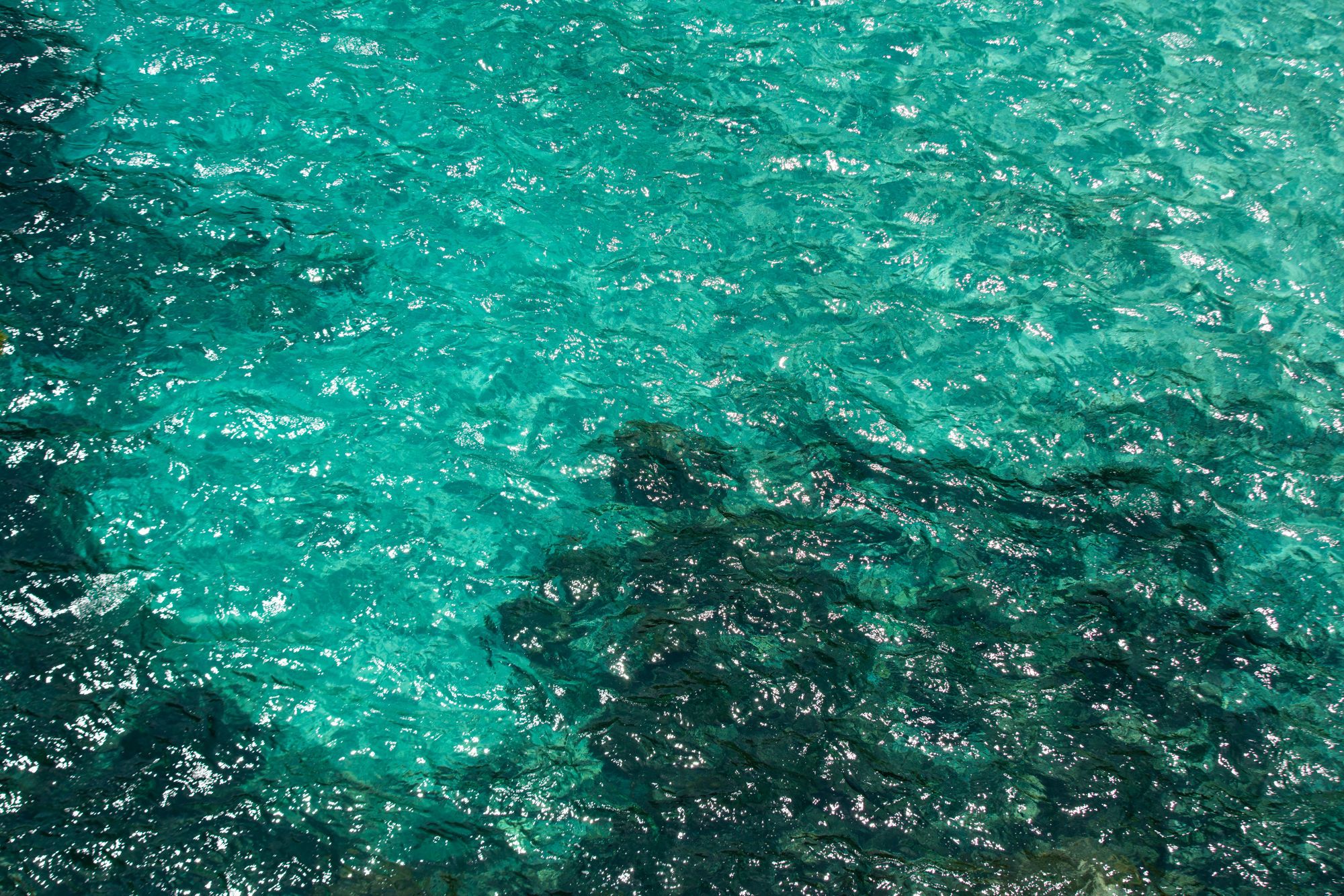 a clear blue water with small ripples