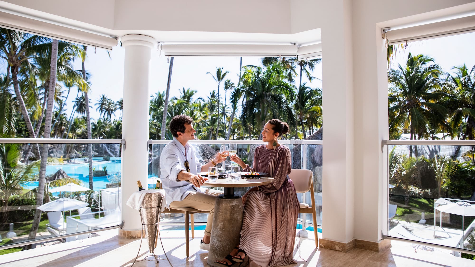 a man and woman sitting at a table with glasses of wine