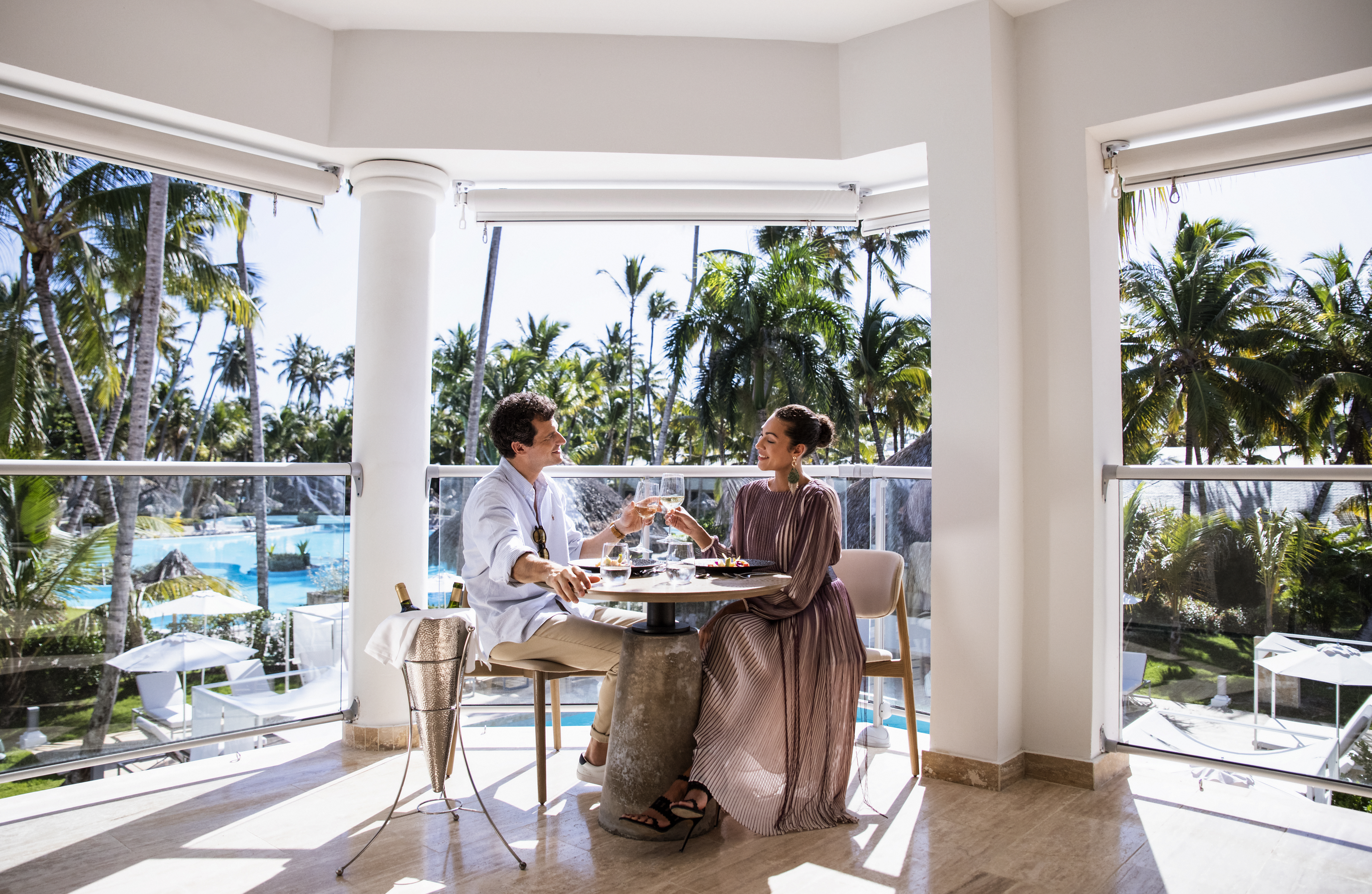 a man and woman sitting at a table with glasses of wine