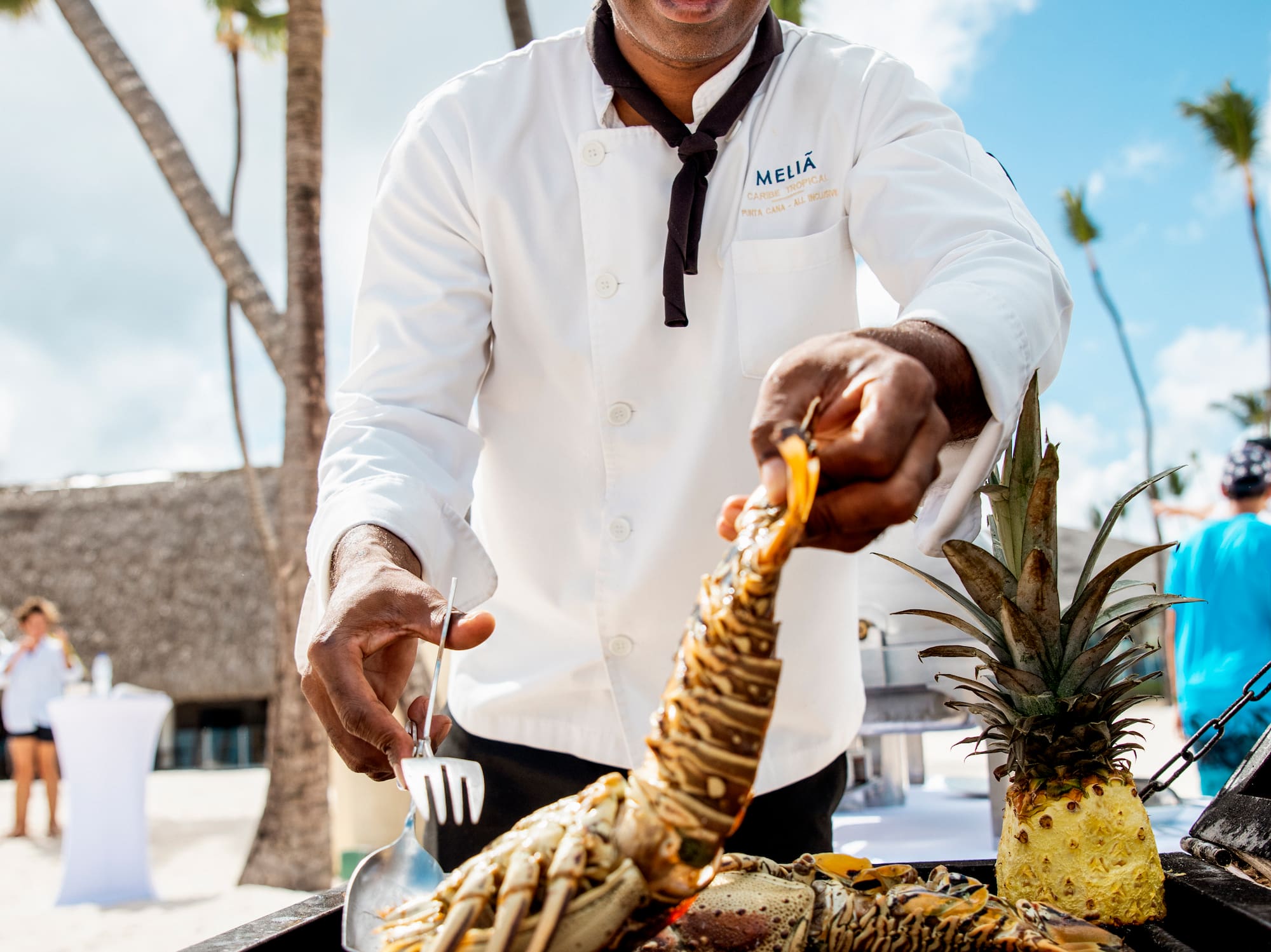 a man cooking lobster on a grill