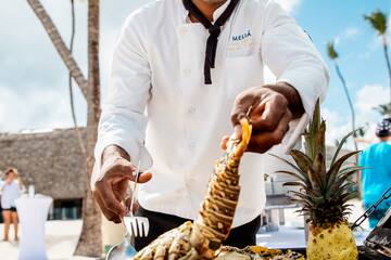 a man cooking lobster on a grill