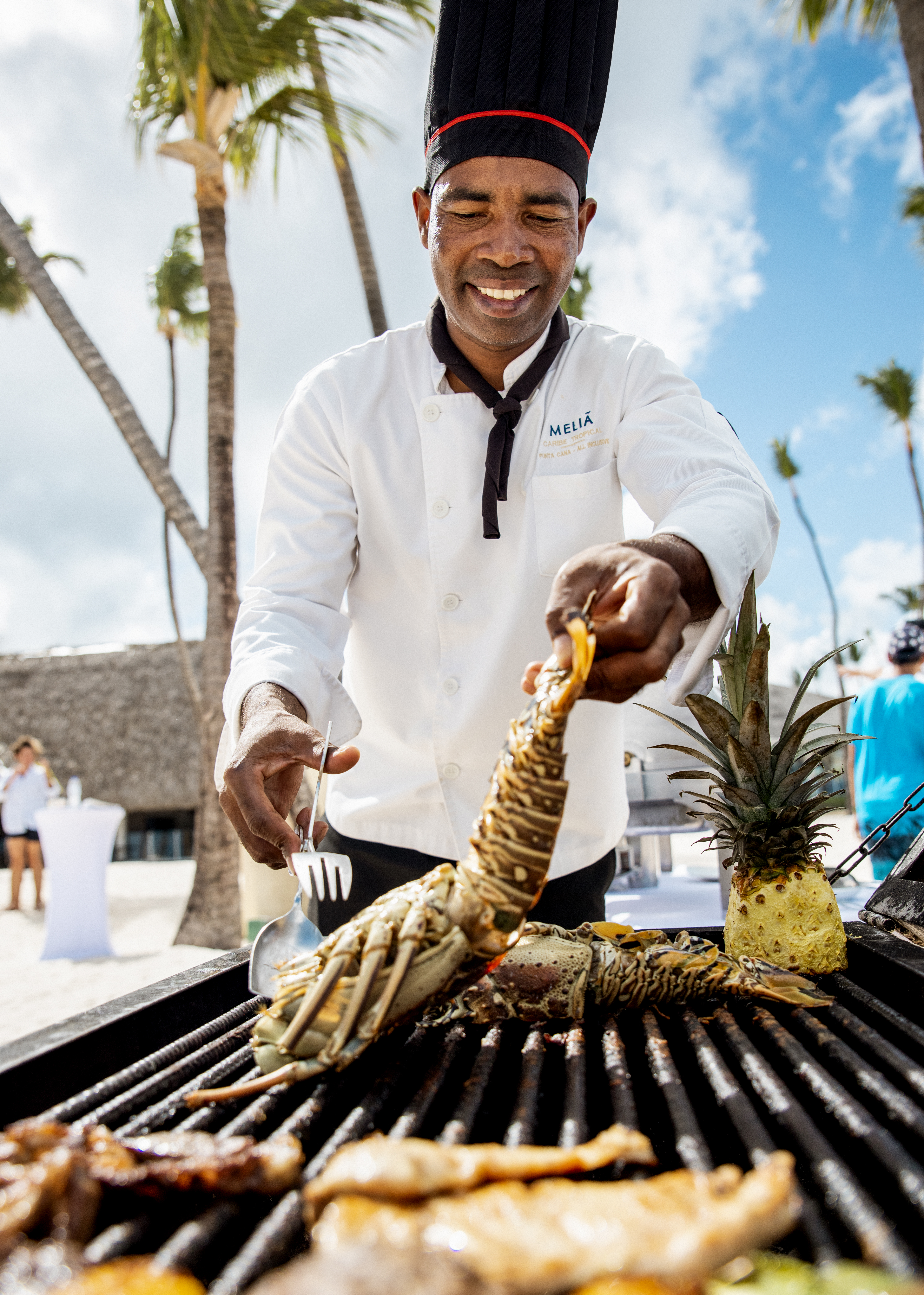 a man cooking lobster on a grill
