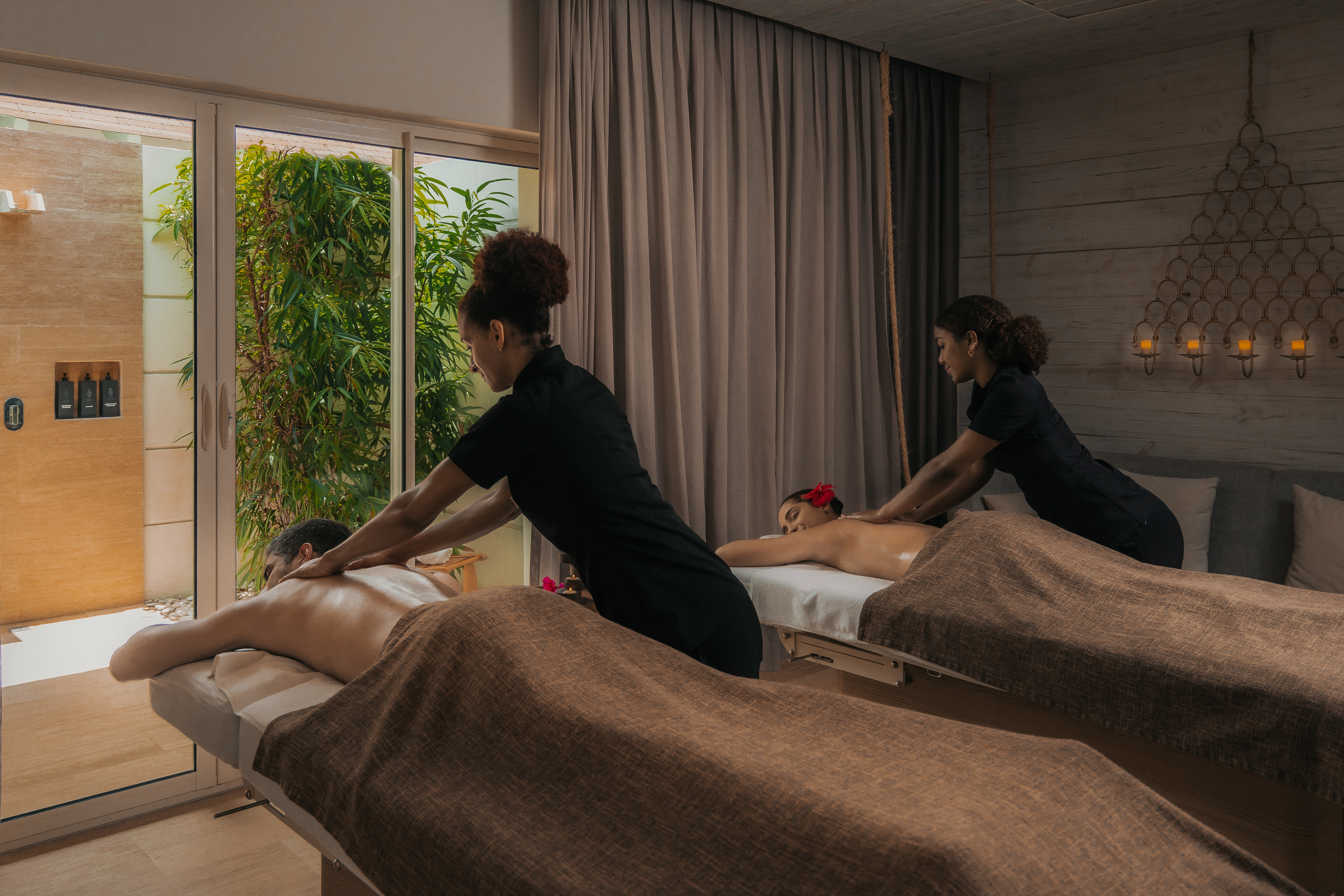 a group of people lying on beds in a room with a window