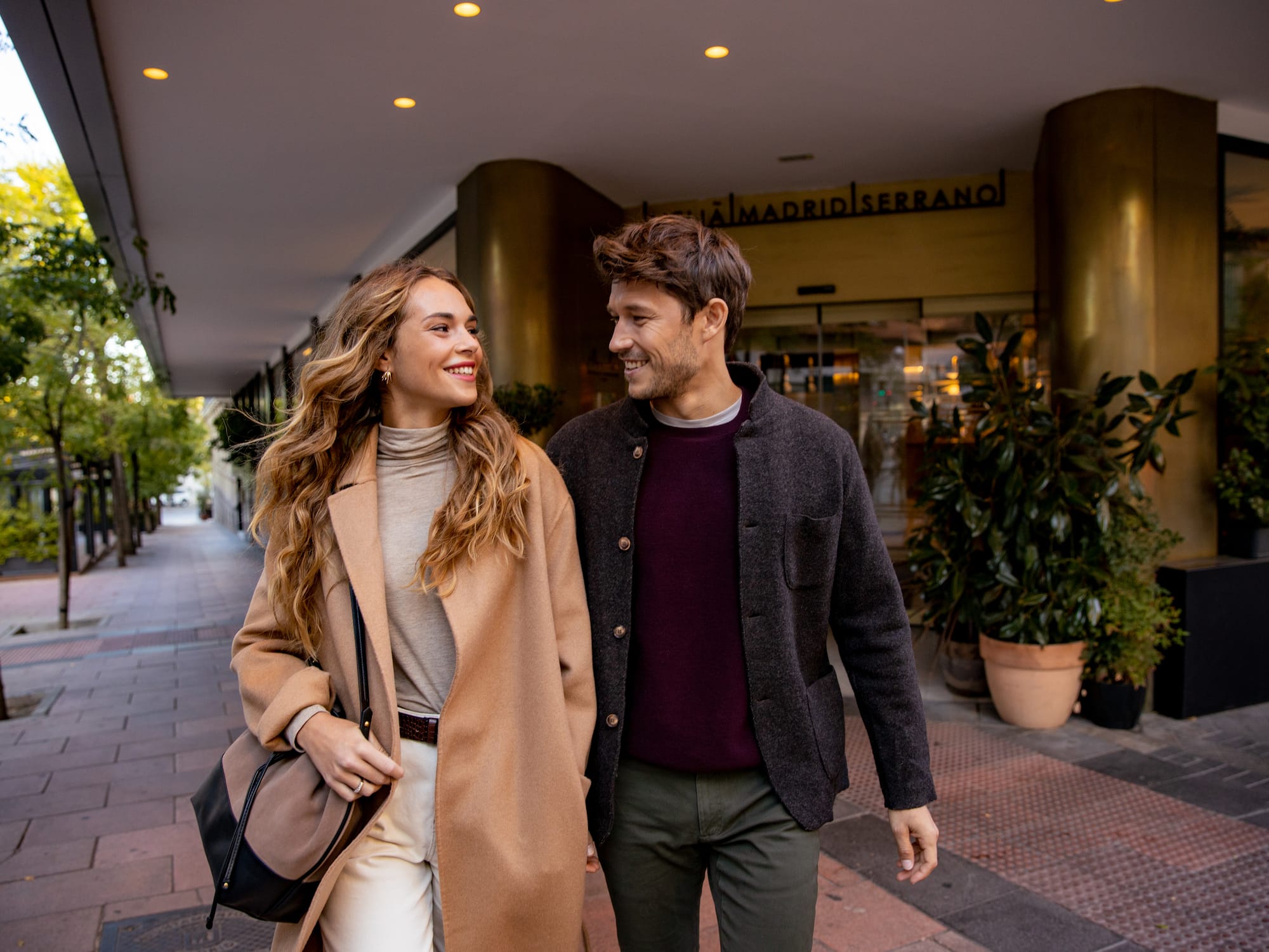 a man and woman walking down a sidewalk