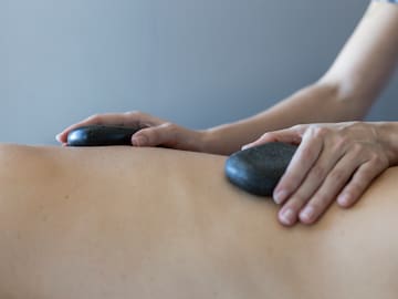 a person receiving a hot stone massage