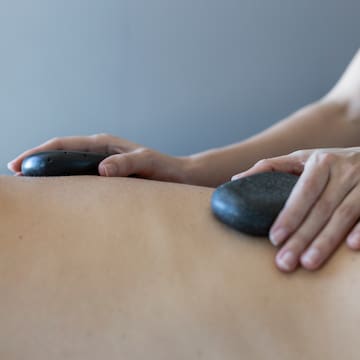 a person receiving a hot stone massage
