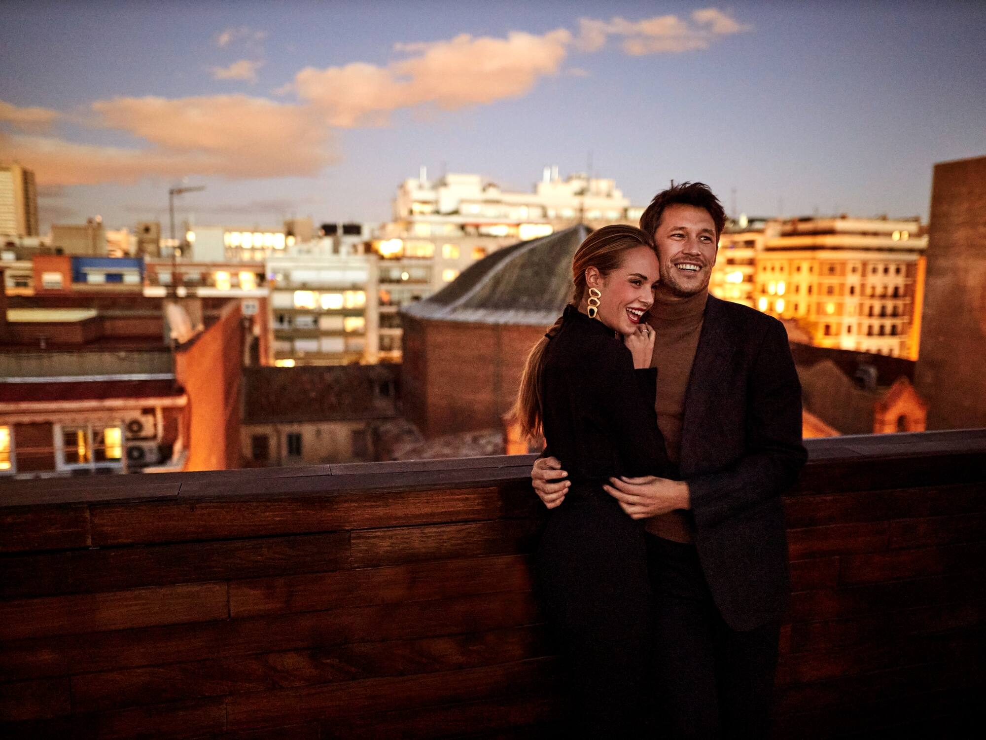 a man and woman hugging on a balcony