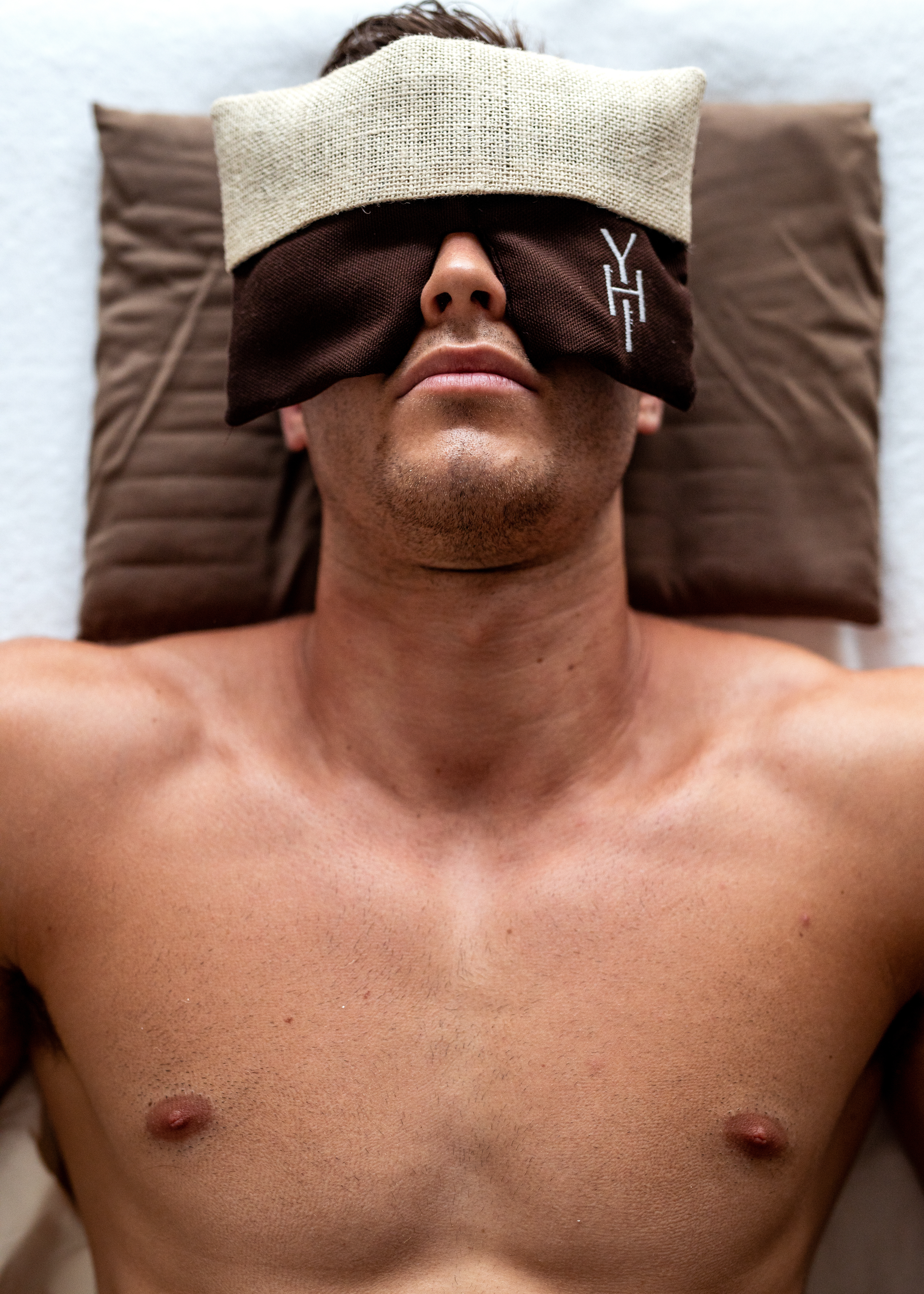 a man lying down with a hat over his eyes
