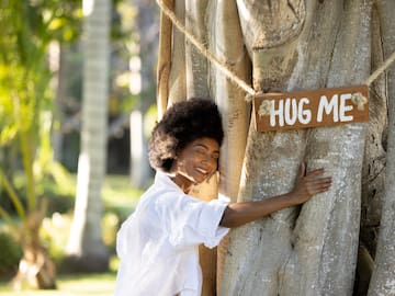 a woman hugging a tree
