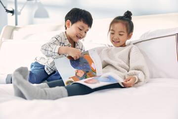 a boy and girl reading a book