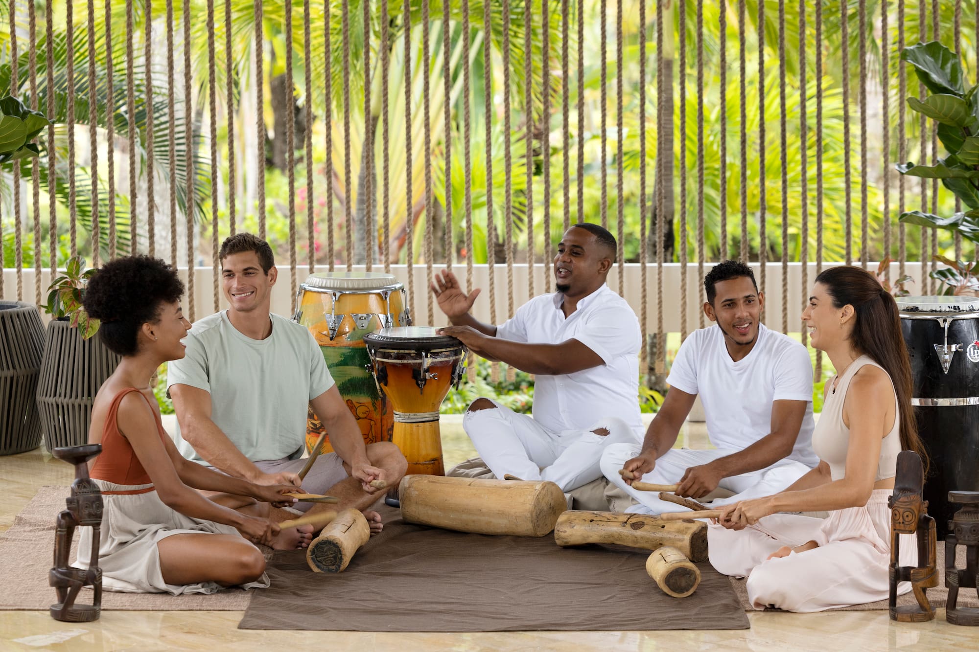 a group of people sitting on the ground playing drums