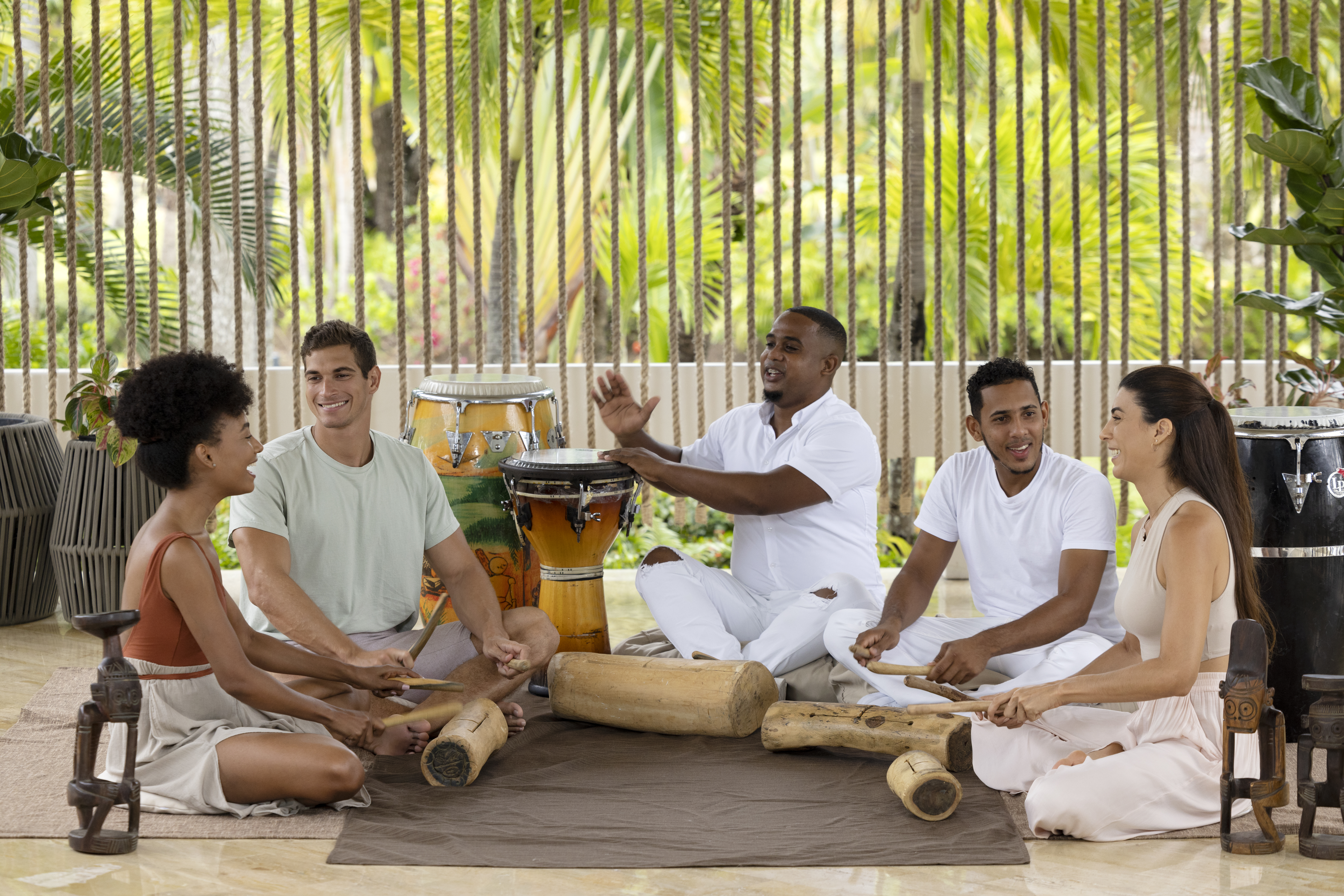 a group of people sitting on the ground playing drums