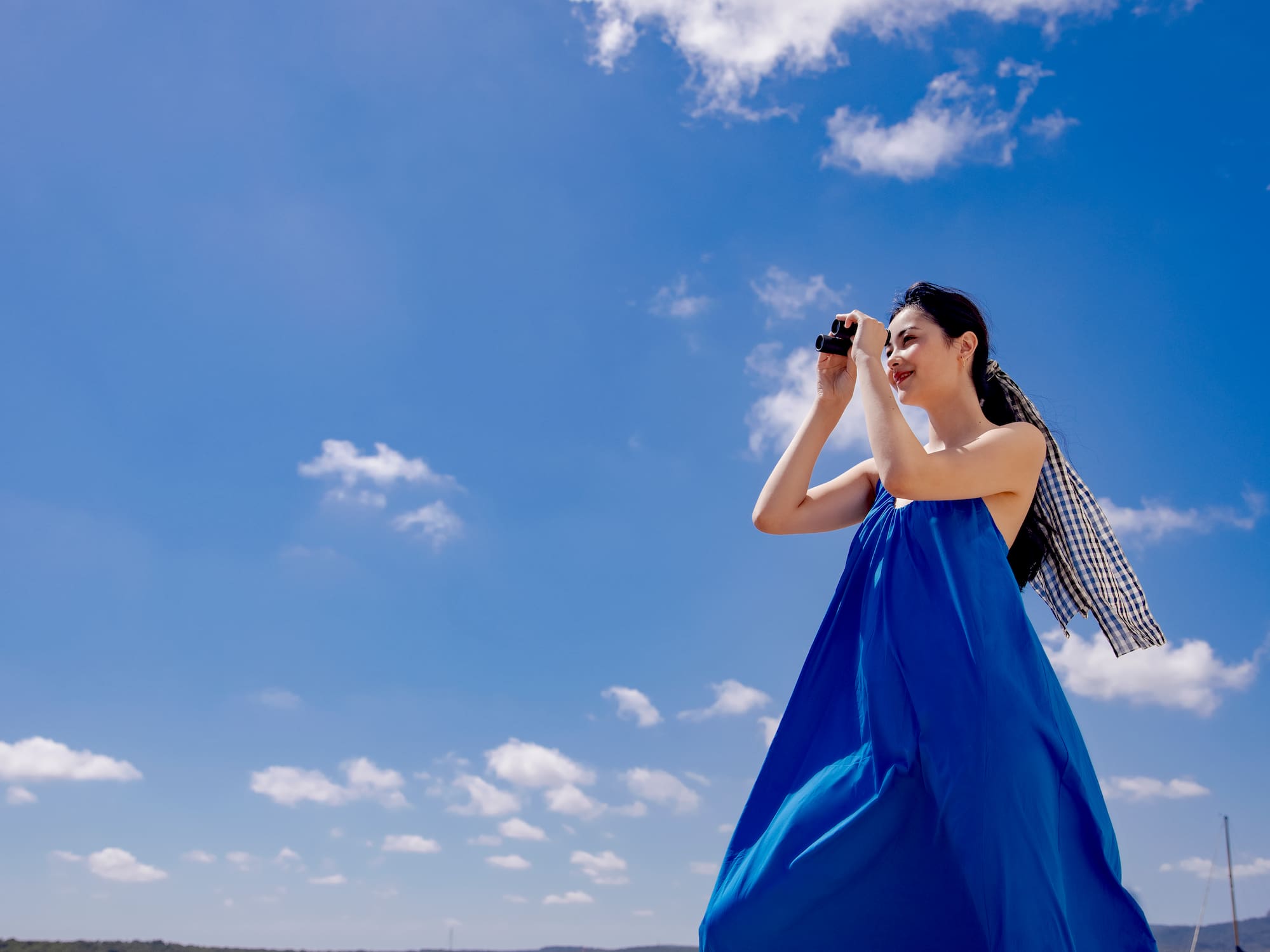 a woman in a blue dress on a beach