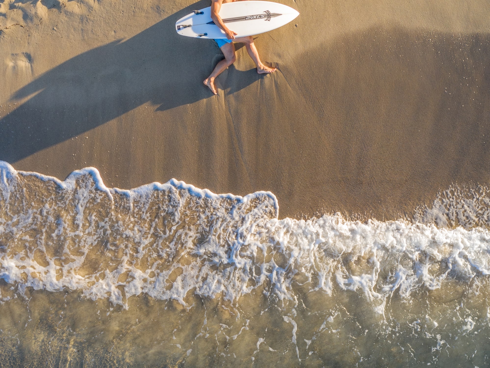 a man lying on the beach with a surfboard