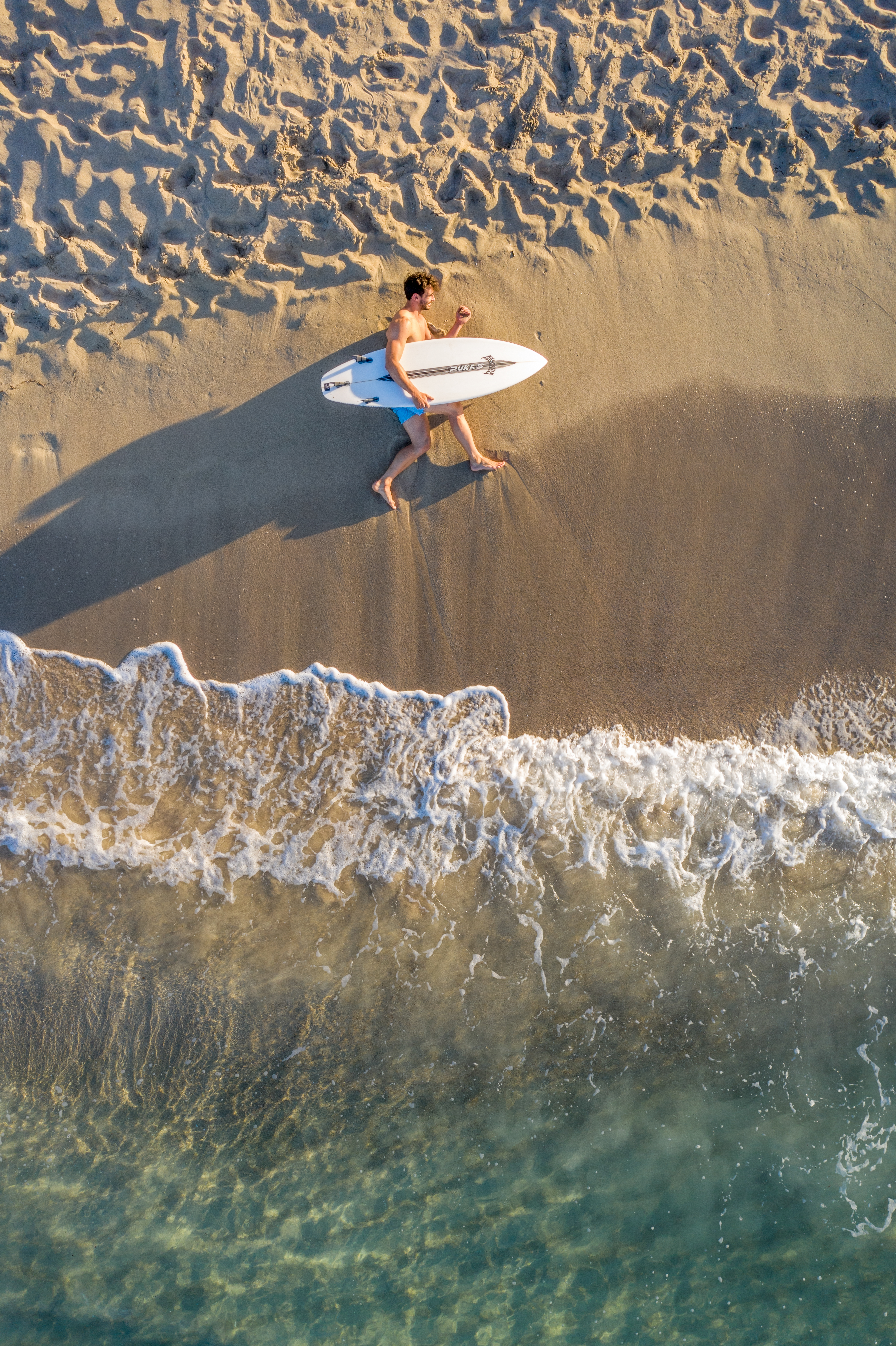 a man lying on the beach with a surfboard