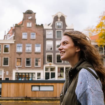 a woman smiling in front of a building
