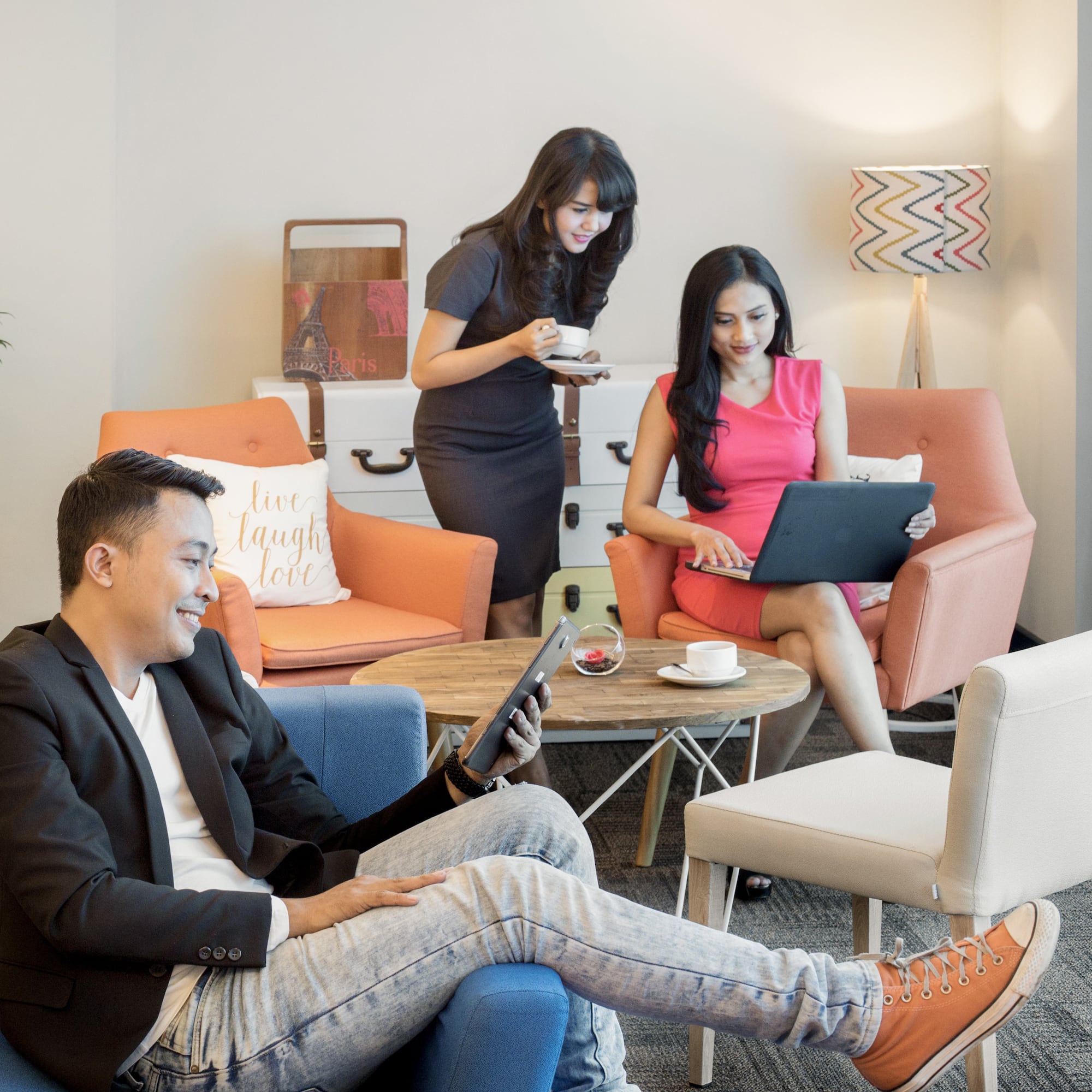 a group of people sitting in chairs and using devices