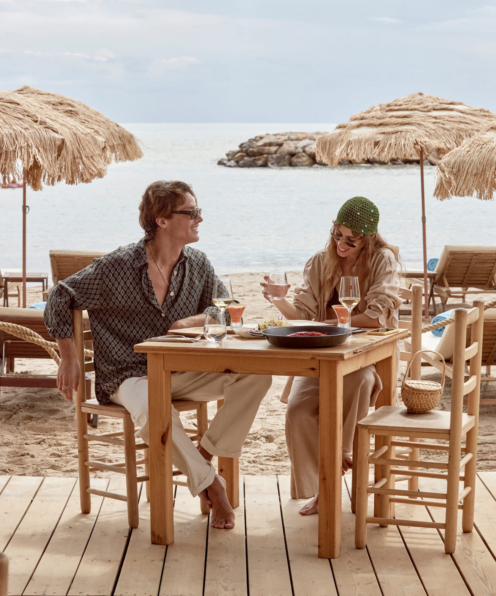 a man and woman sitting at a table with drinks