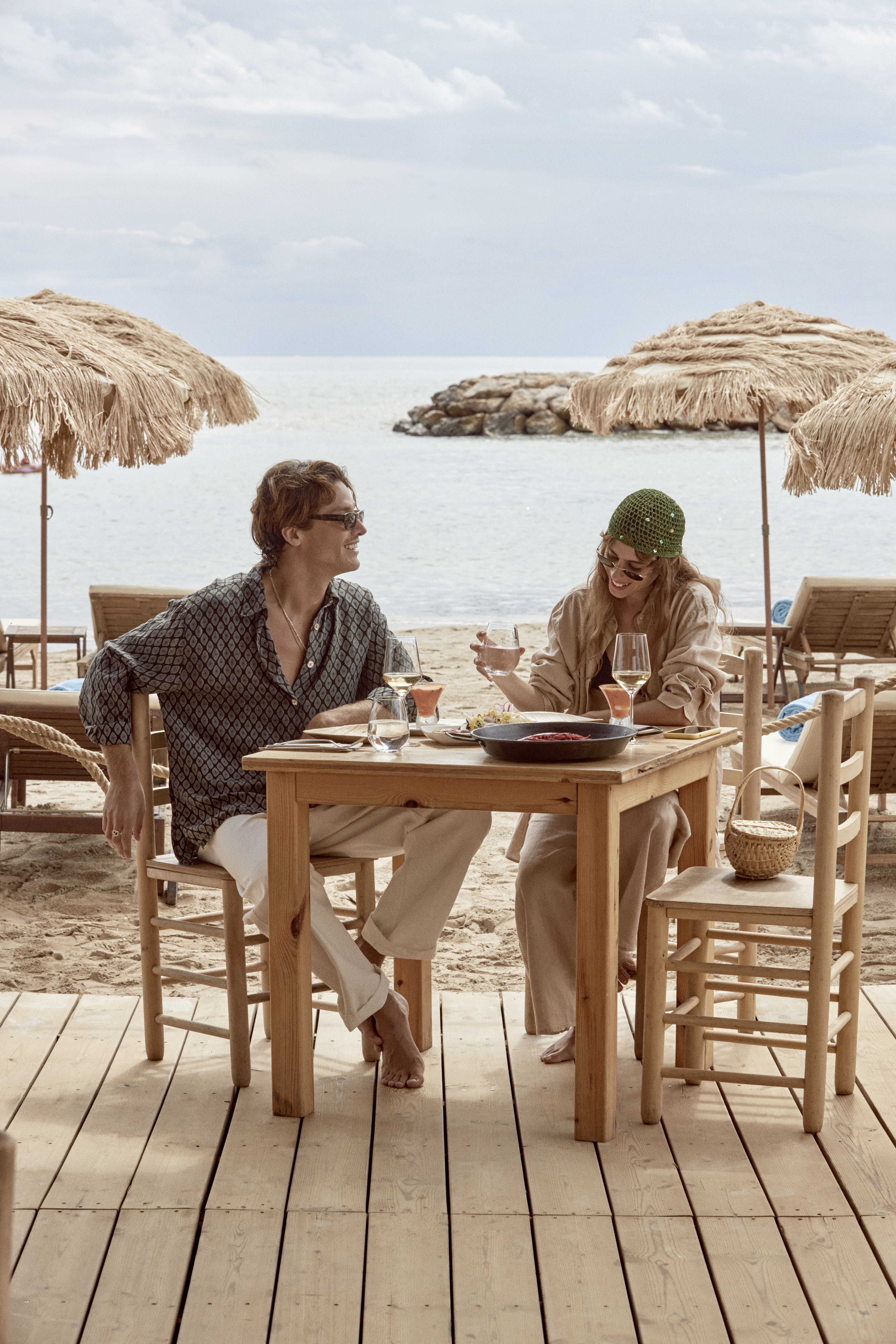 a man and woman sitting at a table with drinks