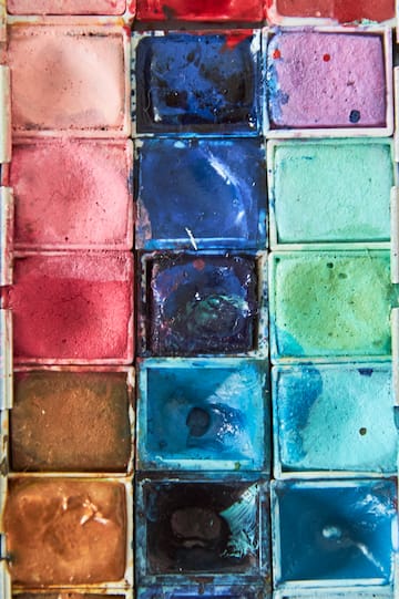 a group of watercolors in a white container