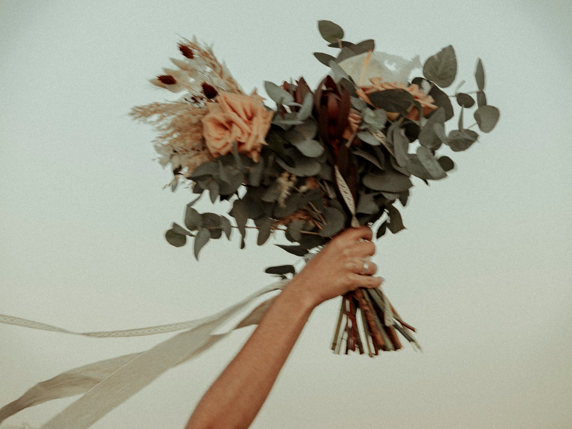 a hand holding a bouquet of flowers
