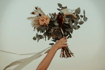 a hand holding a bouquet of flowers