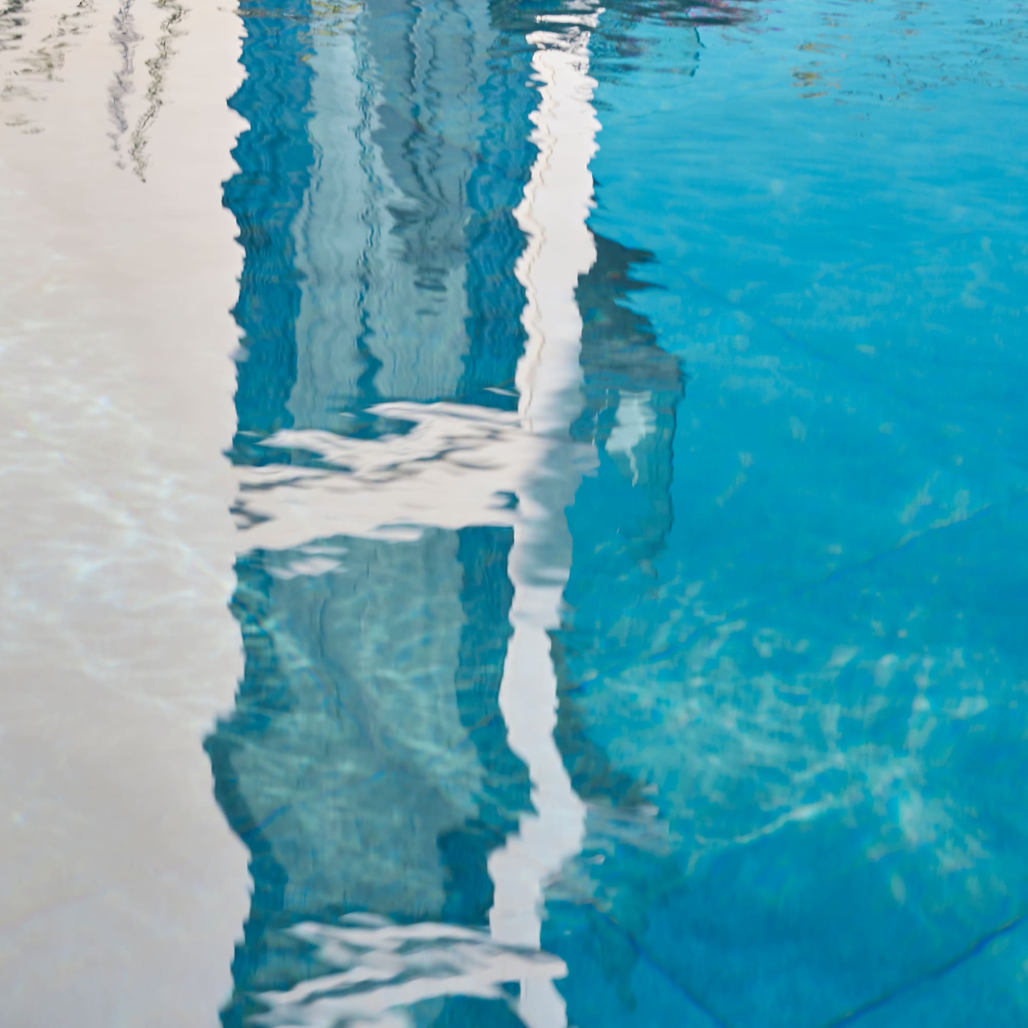a reflection of a building in a pool