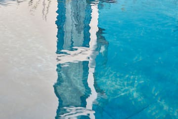 a reflection of a building in a pool