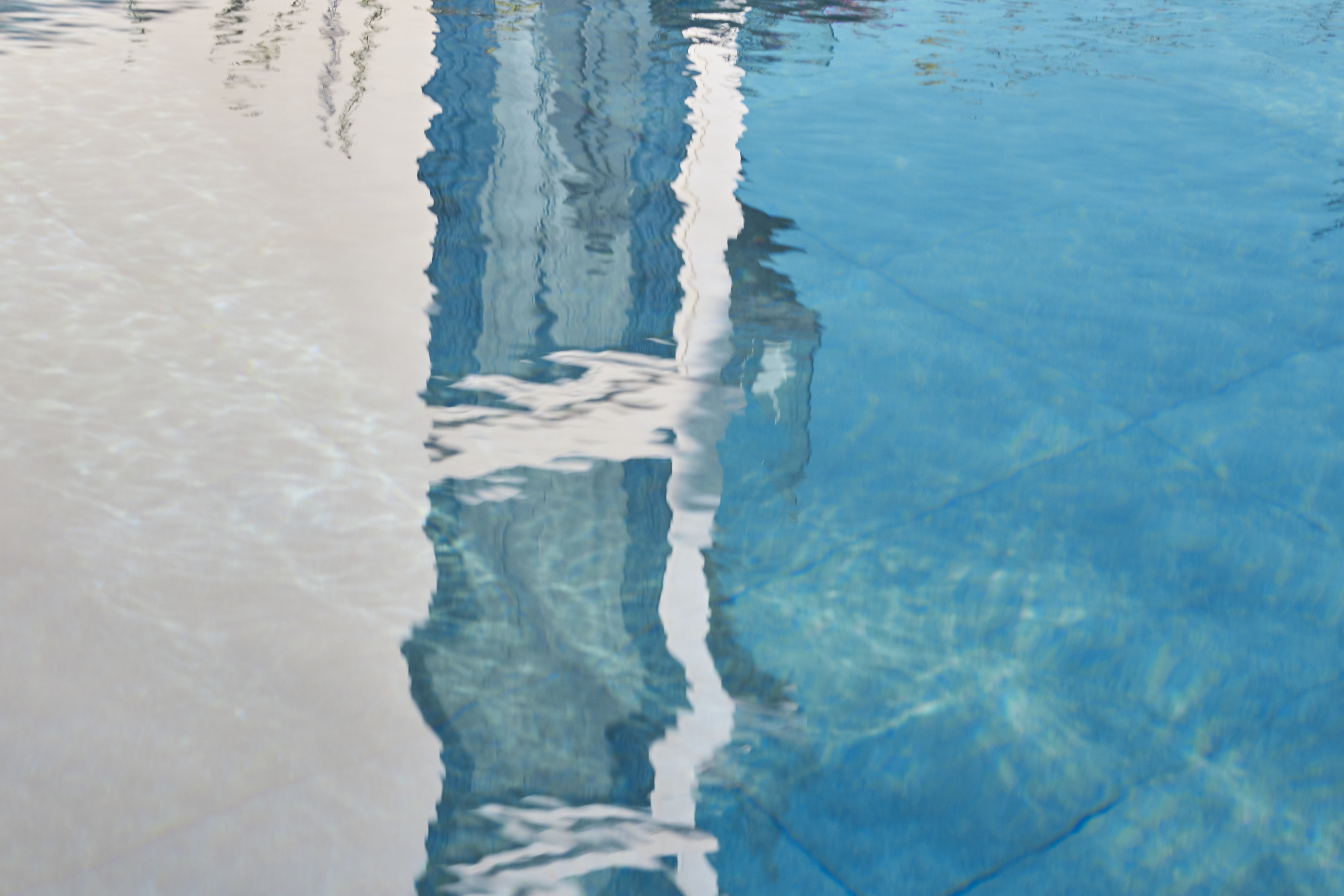 a reflection of a building in a pool