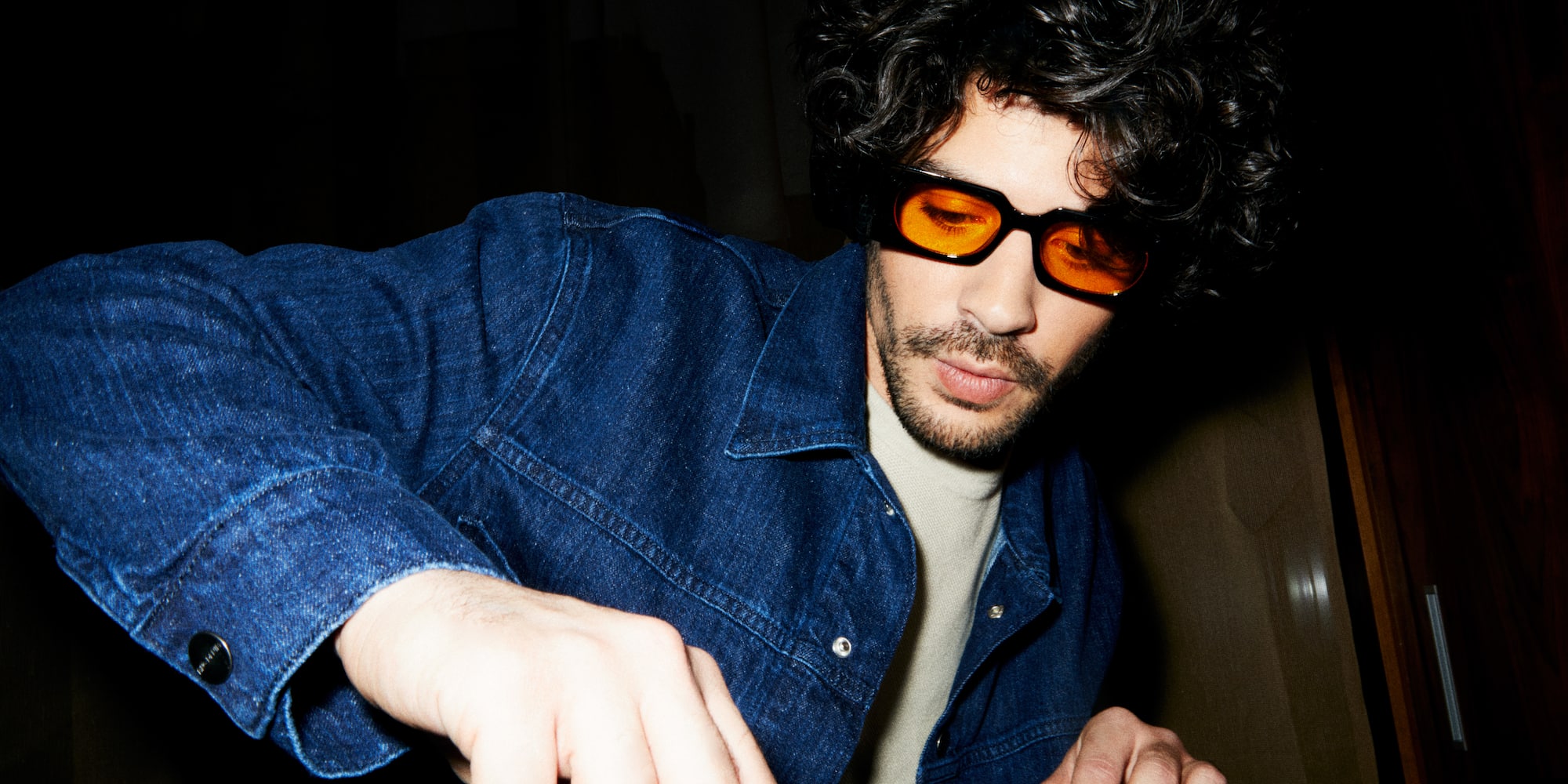 a man wearing sunglasses and a denim jacket