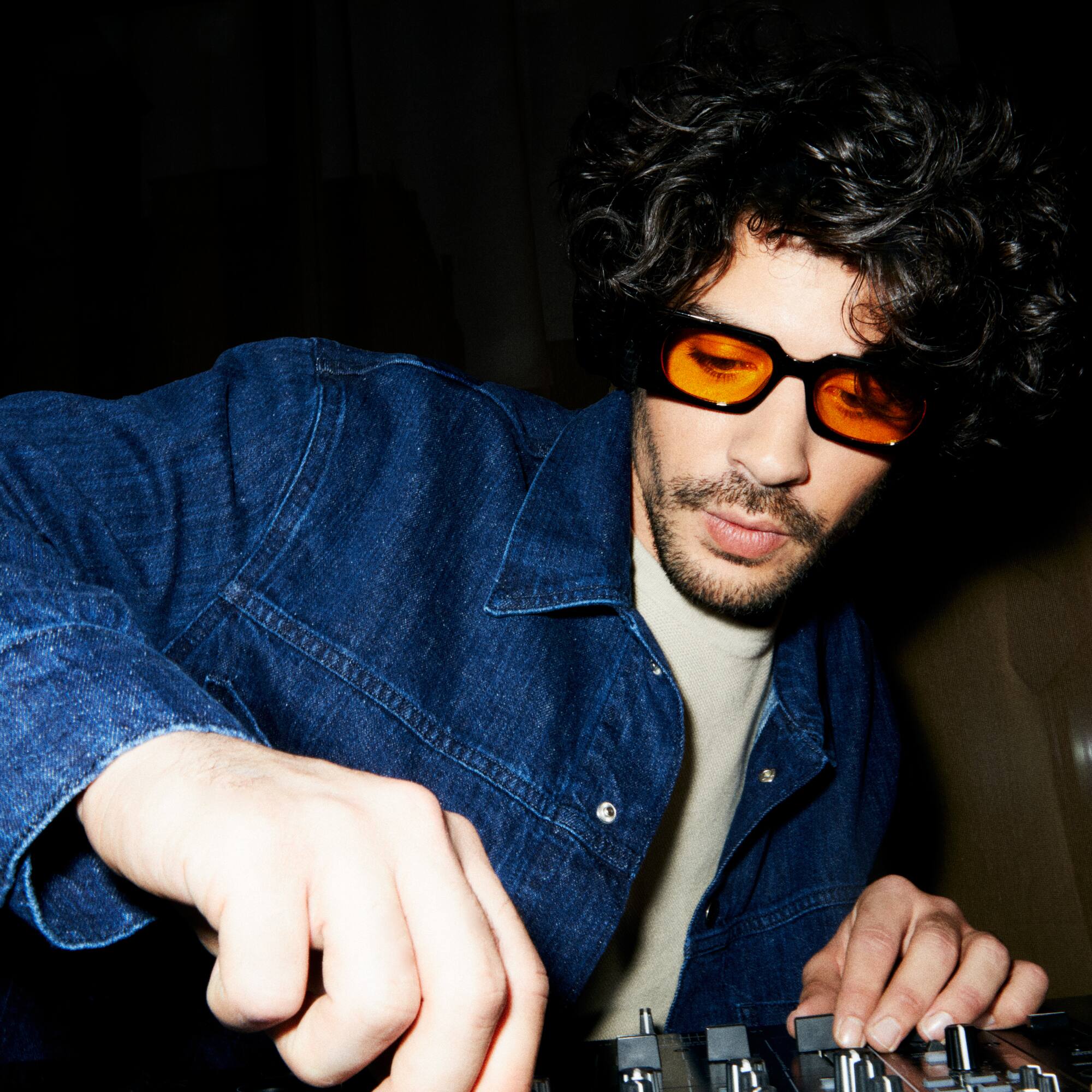 a man wearing sunglasses and a denim jacket