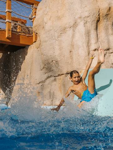 a boy on a slide in a pool