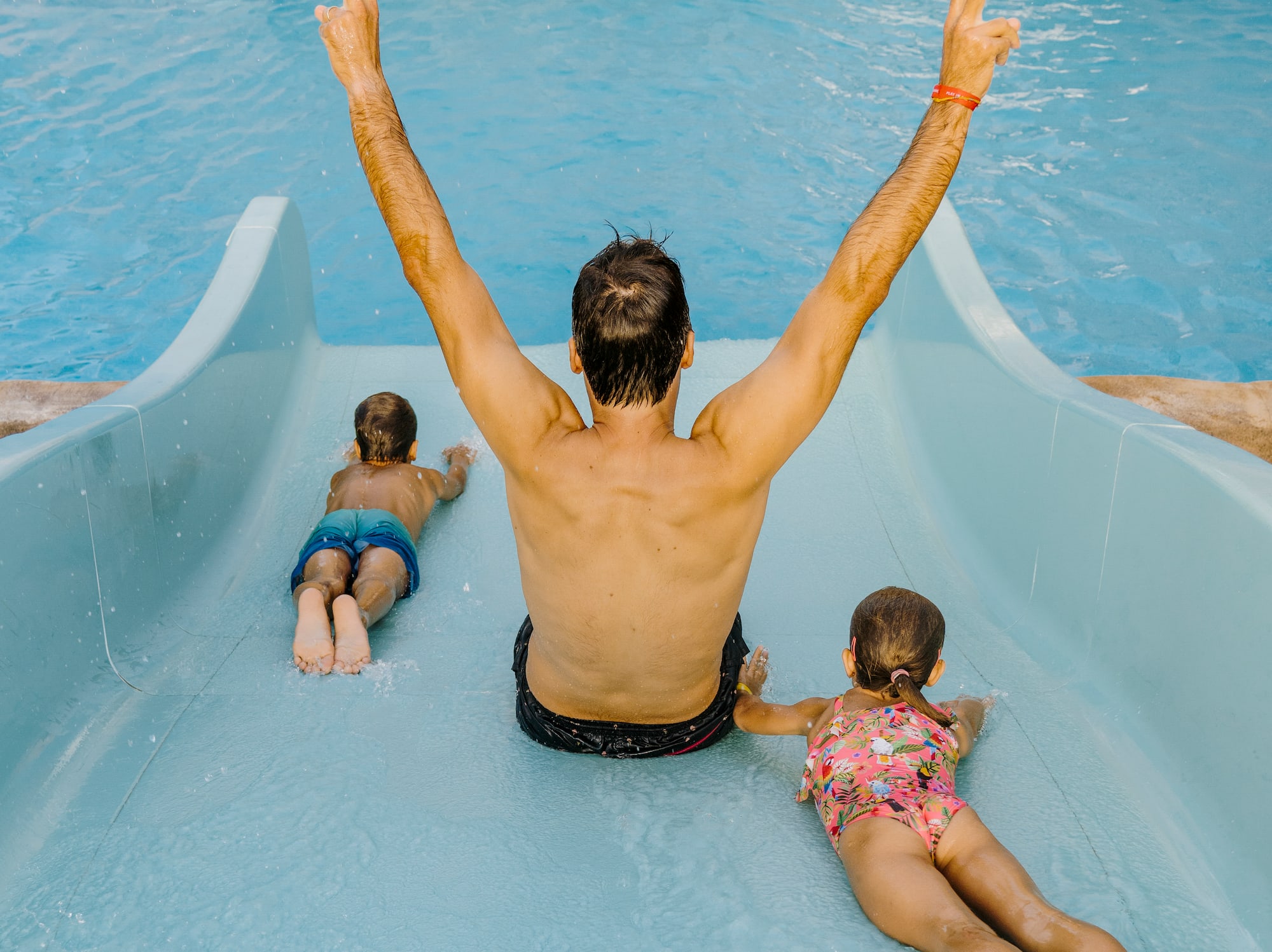 a man and two children on a water slide