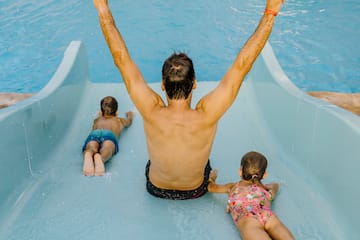 a man and two children on a water slide