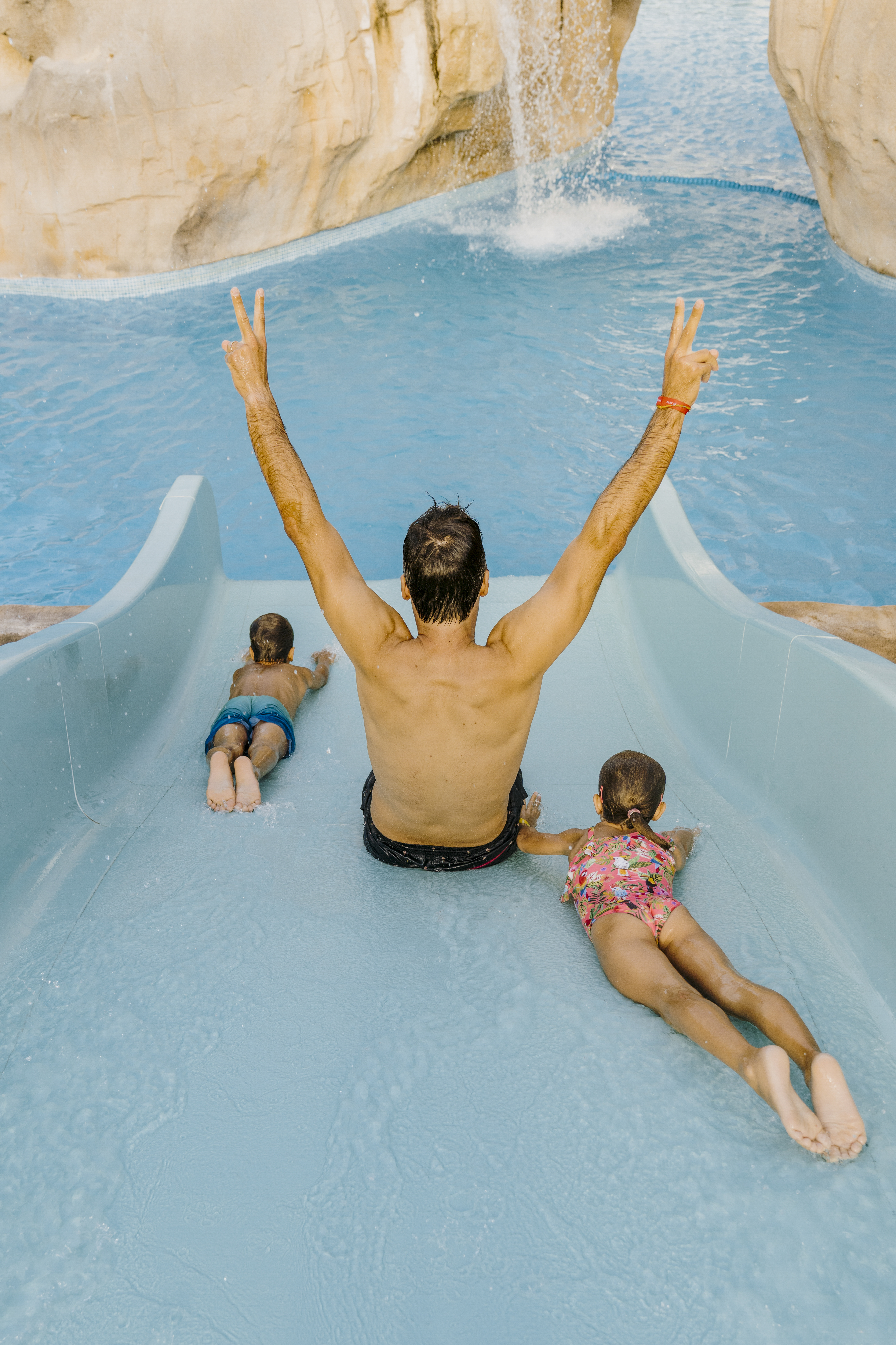 a man and two children on a water slide