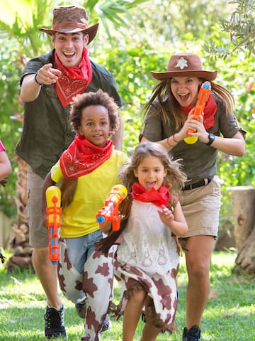 a group of people wearing cowboy hats and holding water guns