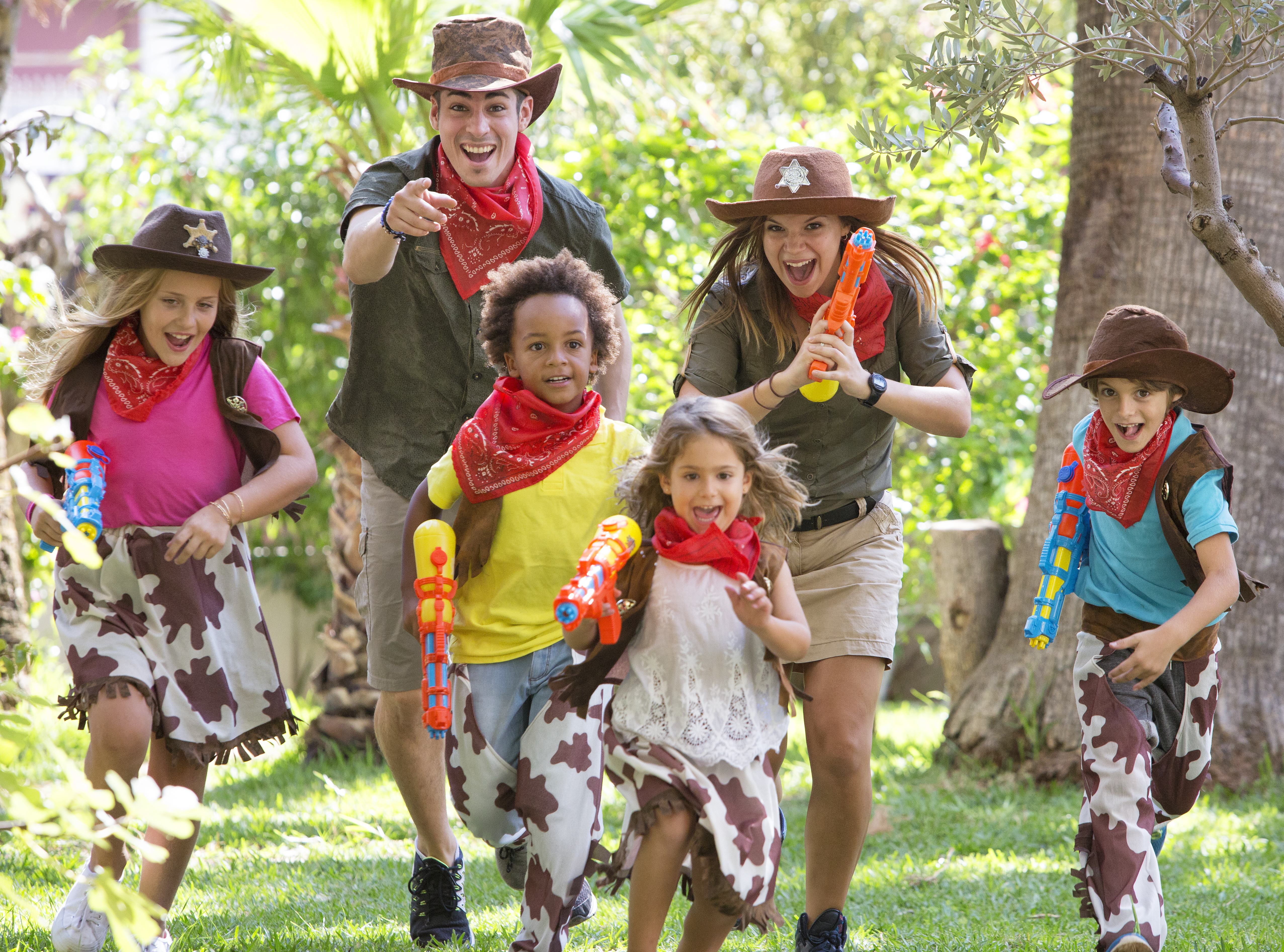 a group of people wearing cowboy hats and holding water guns