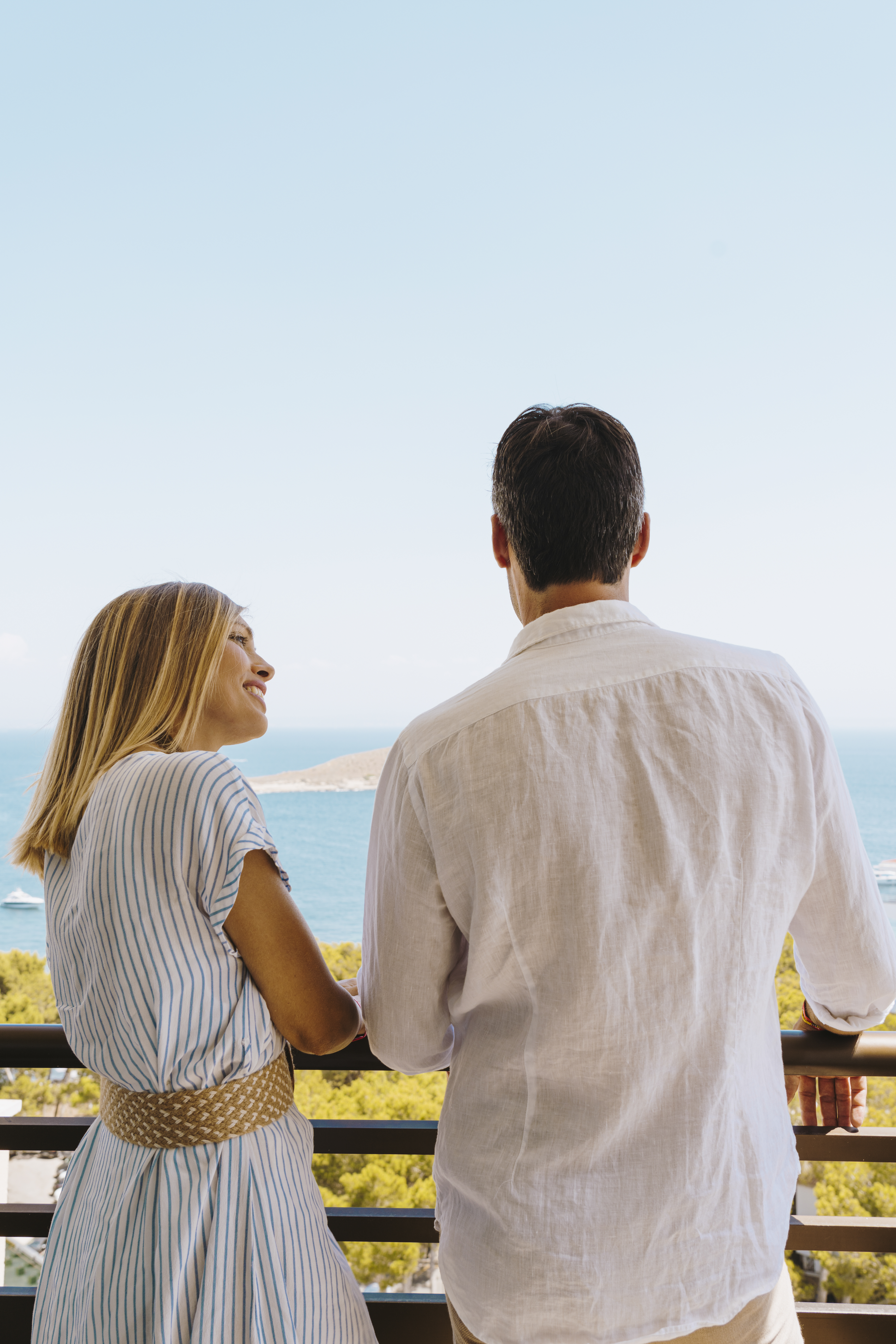 a man and woman looking at the ocean