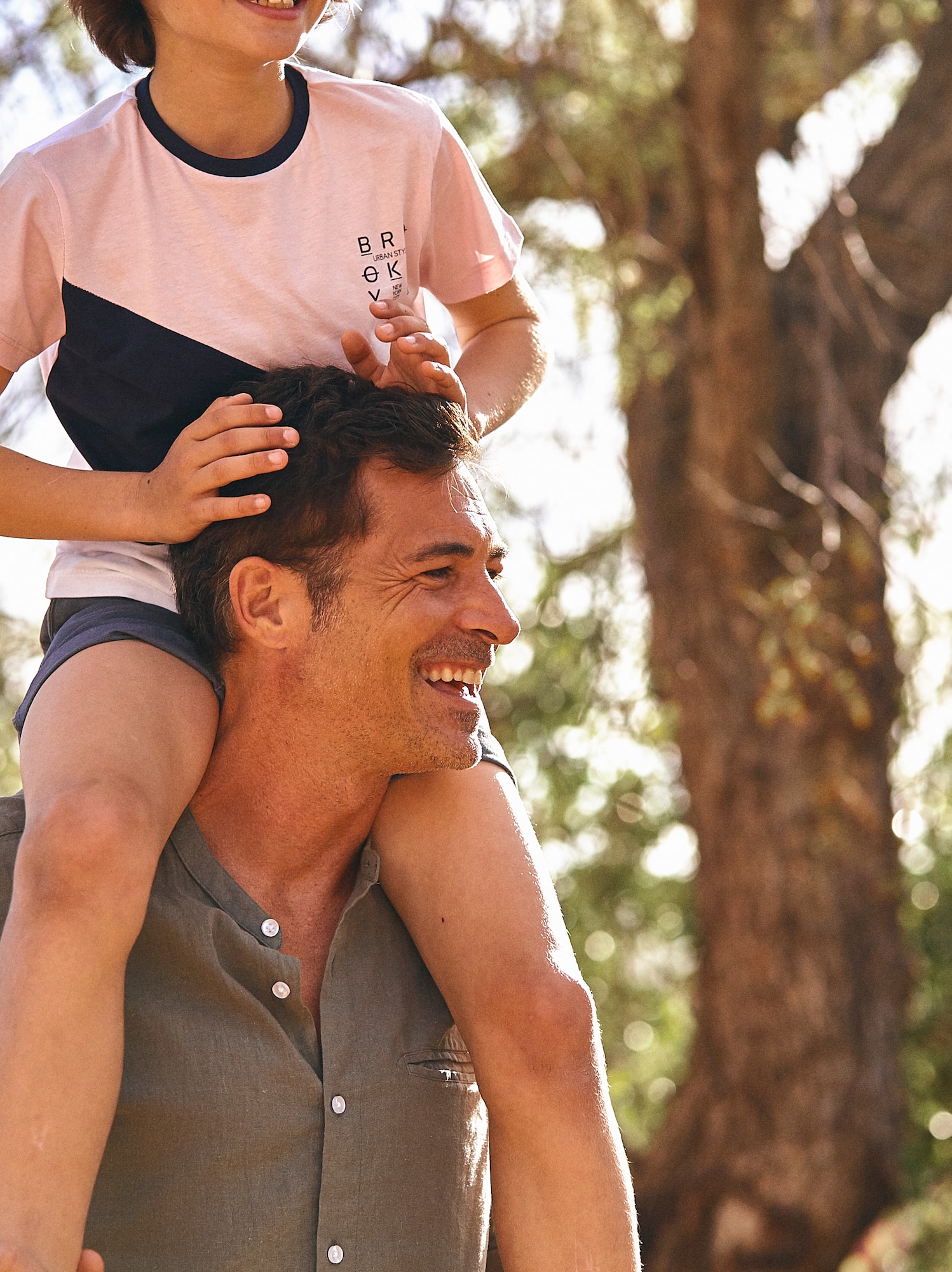 a man carrying a child on his shoulders