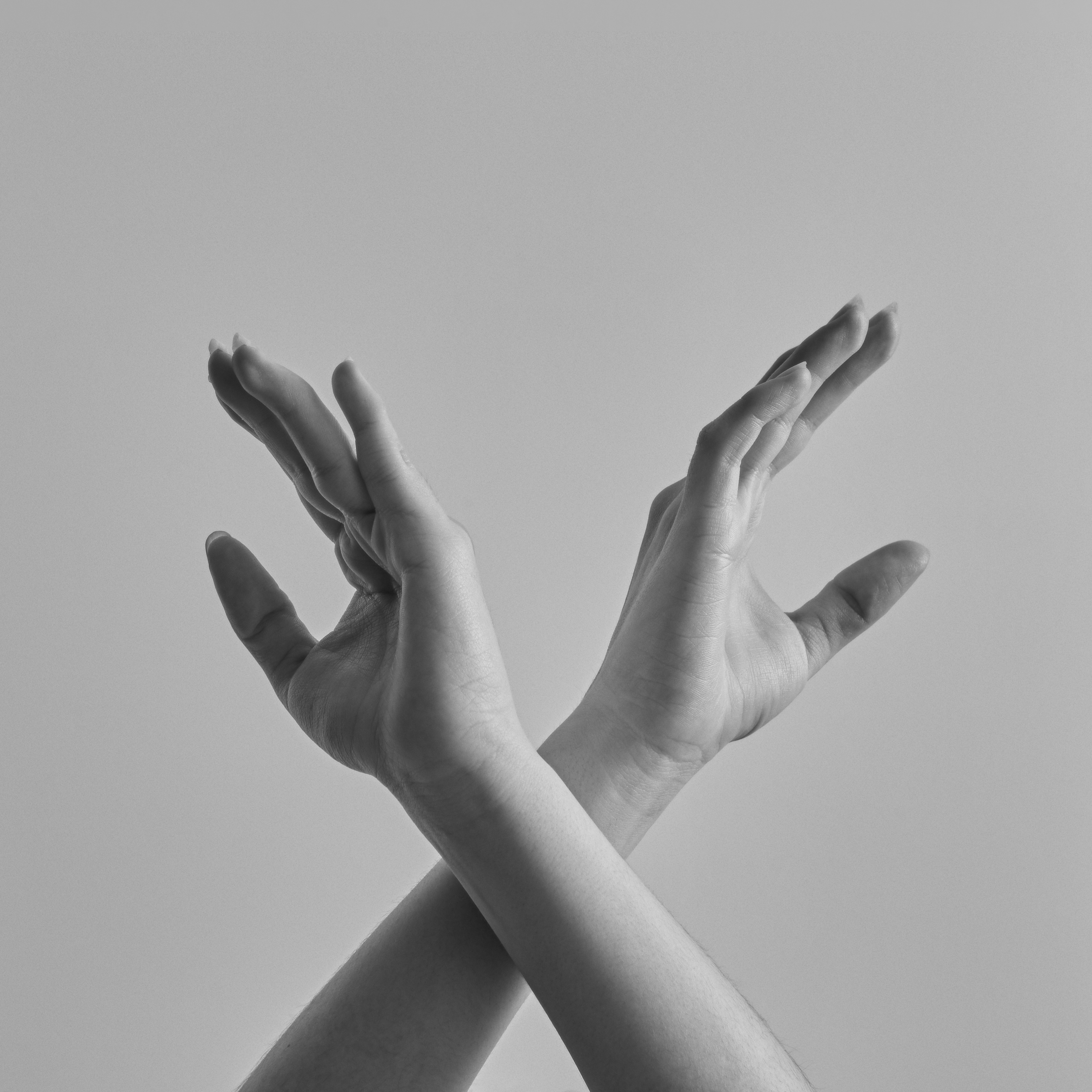 Black and white two crossed hands with spread fingers.
