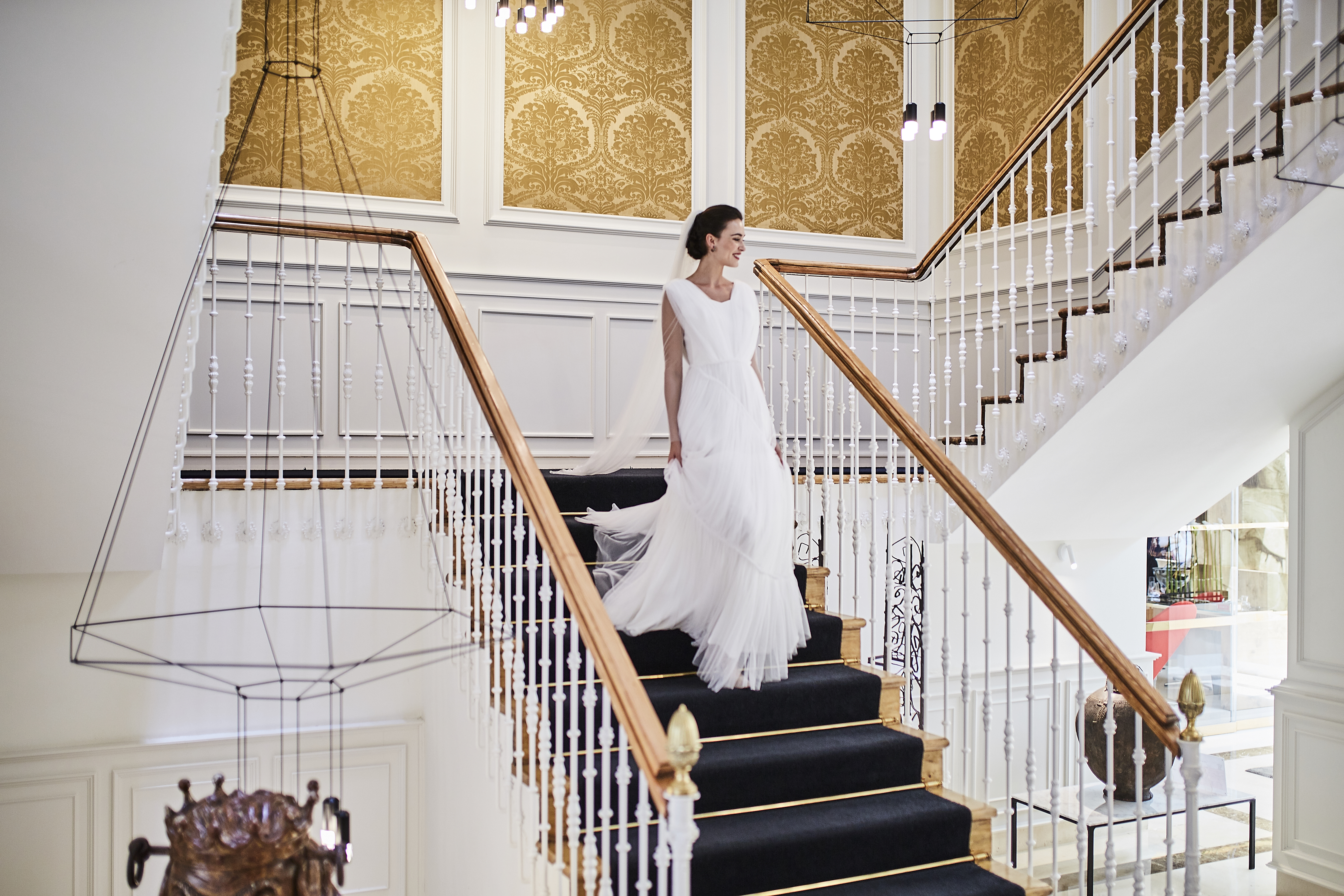 a woman in a white dress walking up the stairs