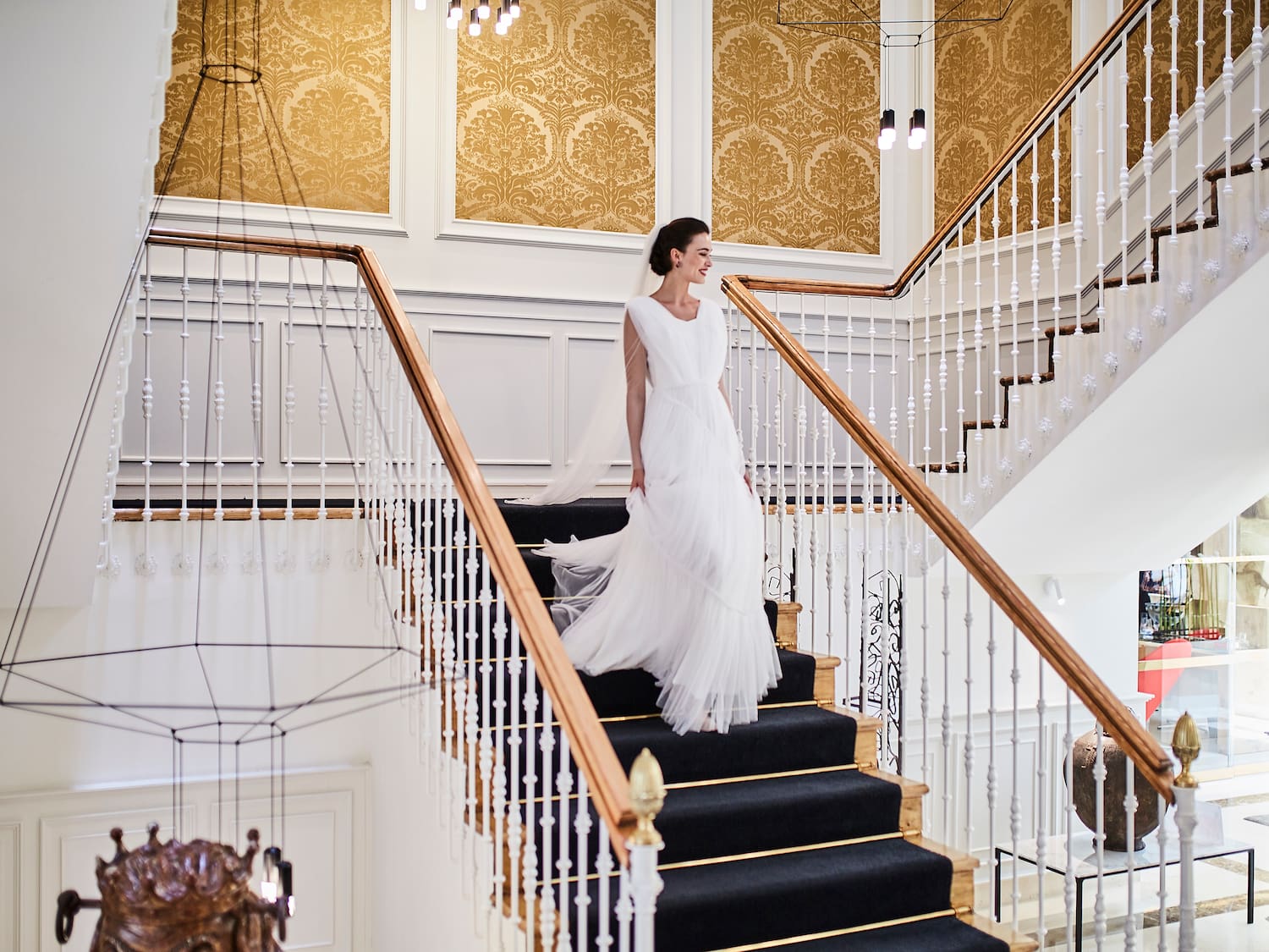 a woman in a white dress walking up the stairs