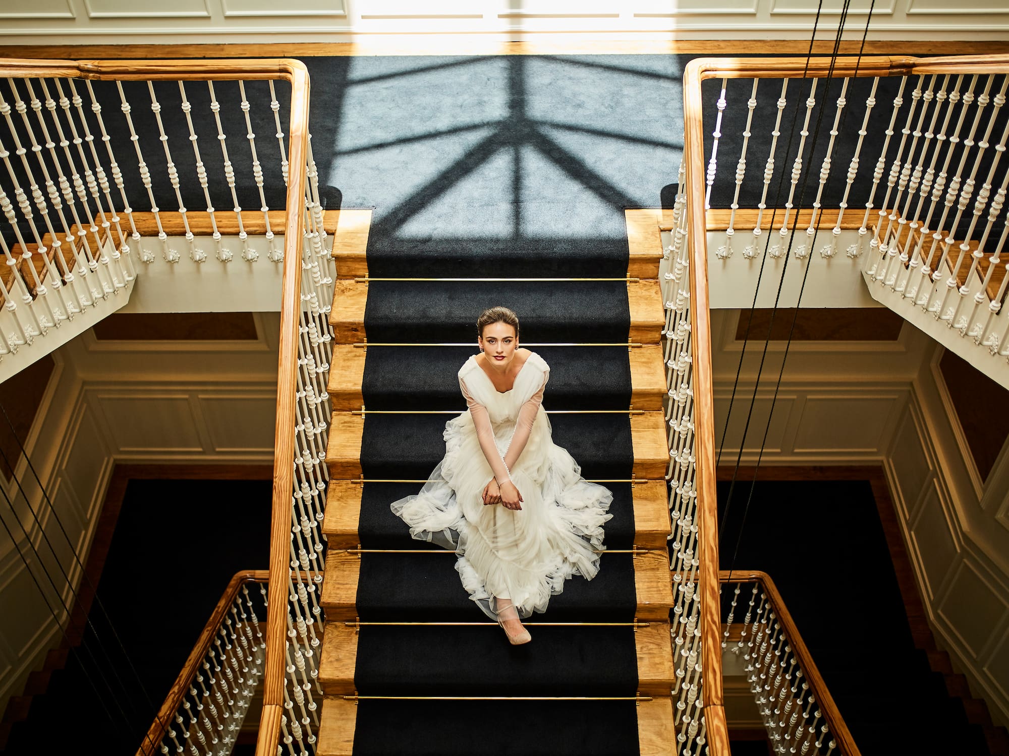 a woman in a white dress sitting on a staircase