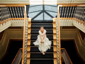 a woman in a white dress sitting on a staircase
